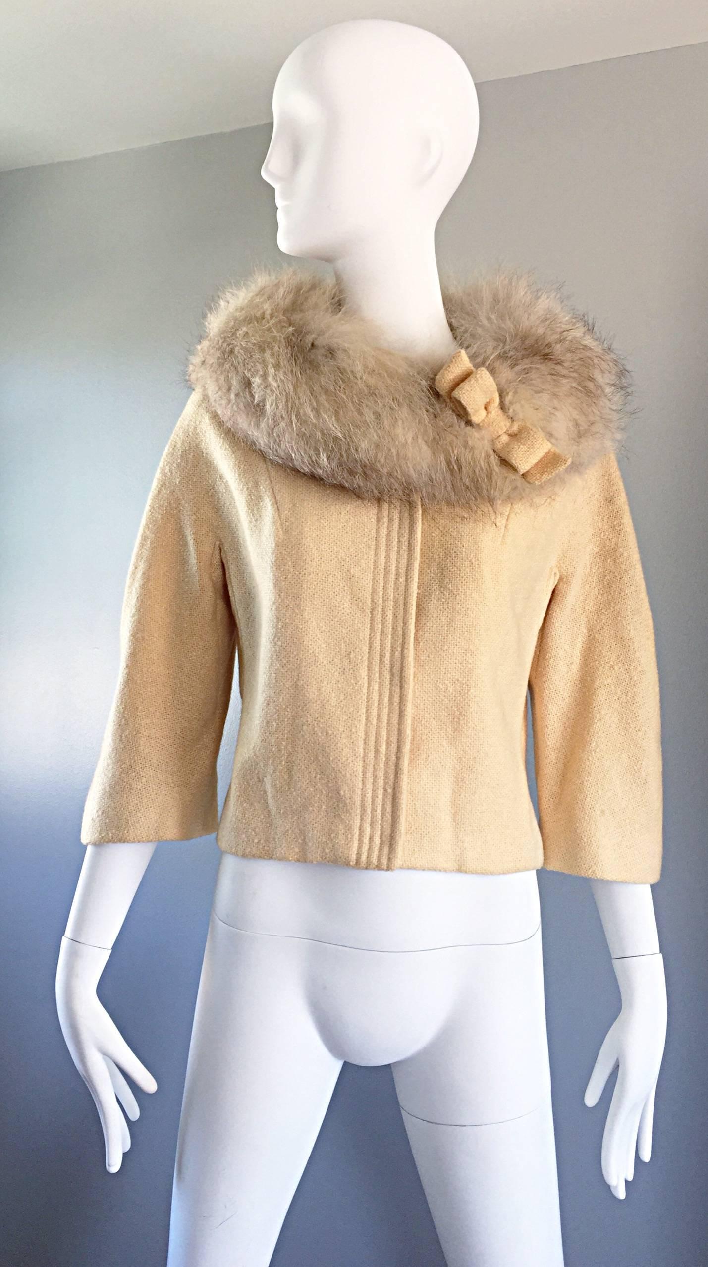 Adorable vintage 60s LILLI ANN ivory cropped swing jacket! Features an oversized fur (probably fox fur) collar with an ivory wool bow detail. Classic swing style flatters all shapes and sizes! Fully lined in silk. Hidden snaps up the bodice and at