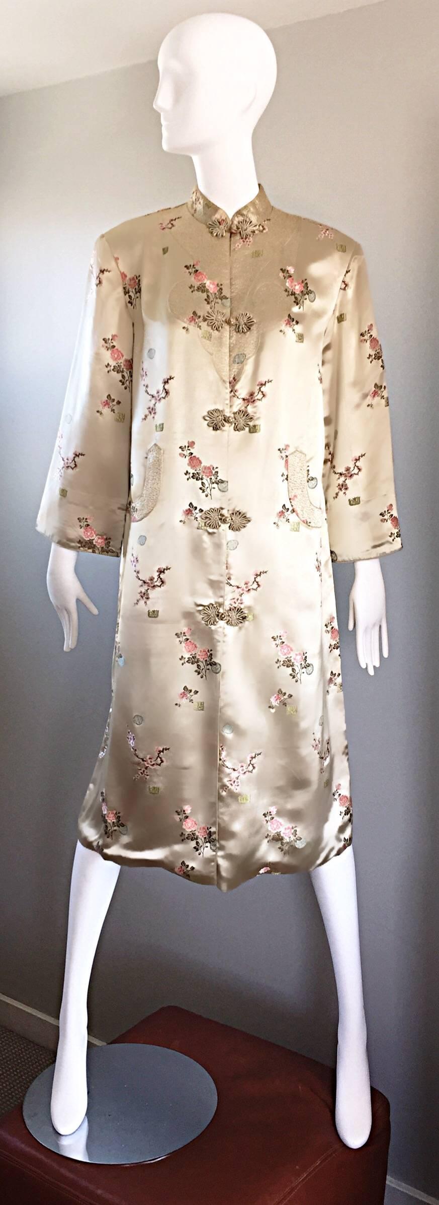 Absolutely breathtaking vintage 1960s silk couture Asian kimono jacket! Features the finest of light gold silk, with a beautiful colorful flowers embroidered throughout. Hand sewn intricate stitching details on the bodice, sleeve cuffs, and at each