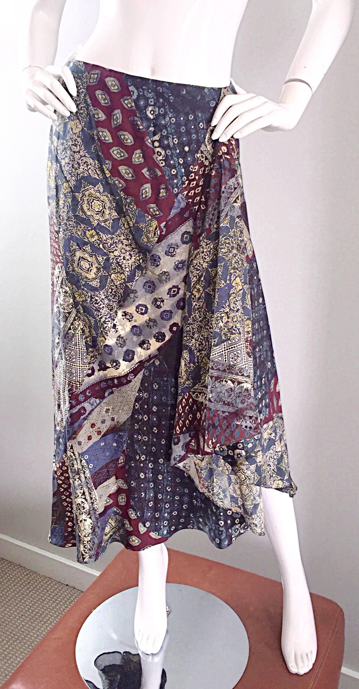 Incredible vintage KENZO 1970s silk boho asymmetrical skirt! Features allover paisley prints in warm hues of blue, burgundy and Ivory. Asymmetrical on one side. The patterns and colors of this gem make for the perfect bohemian vibe! Hidden zipper up