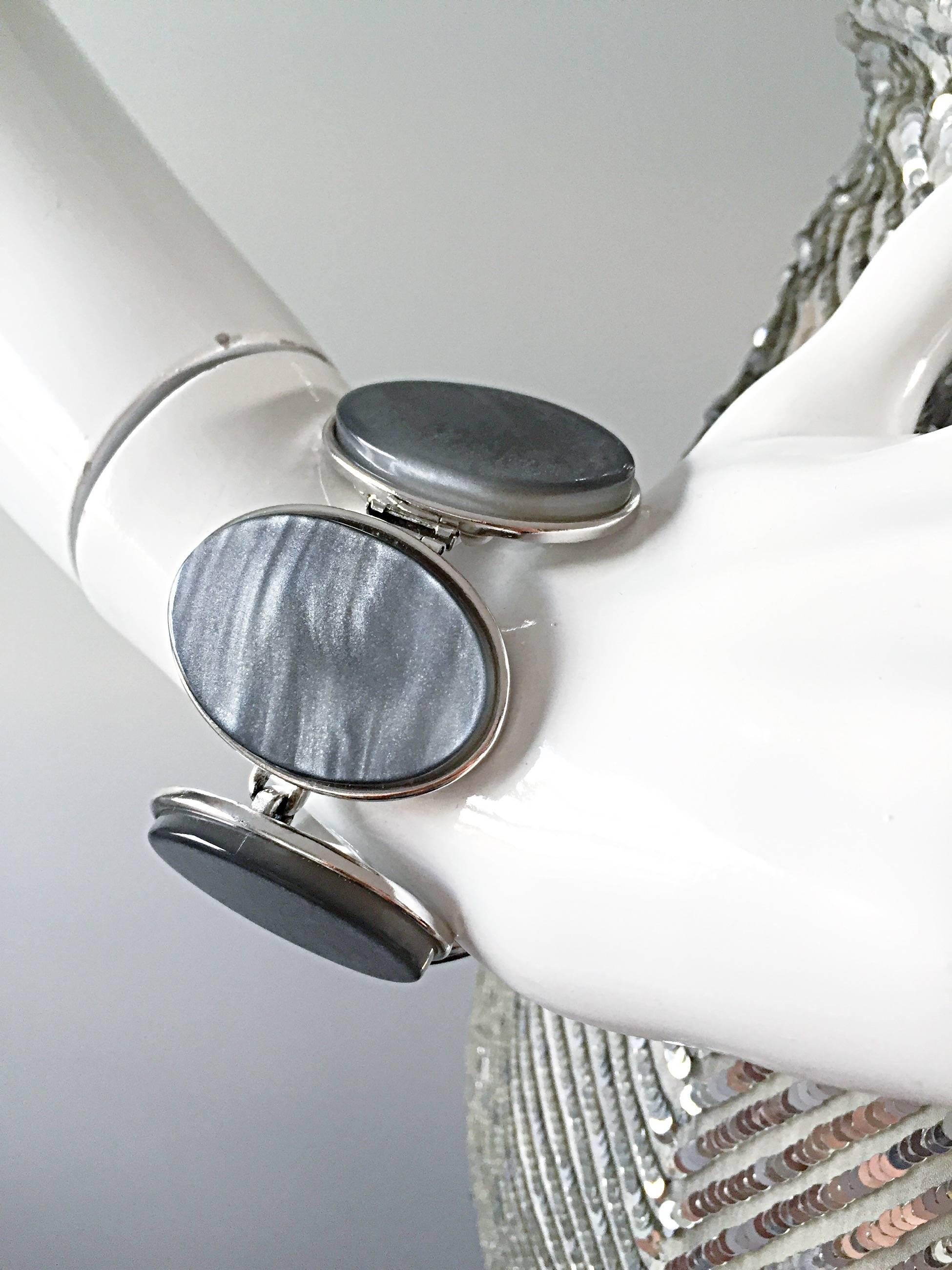 Beautiful vintage YVES SAINT LAURENT silver/grey iridescent oval bracelet! Each oval varies with pattern, and gives so much to any outfit! Six ovals on silver links. In great unworn condition. Made in France. Measures 8 inches long.