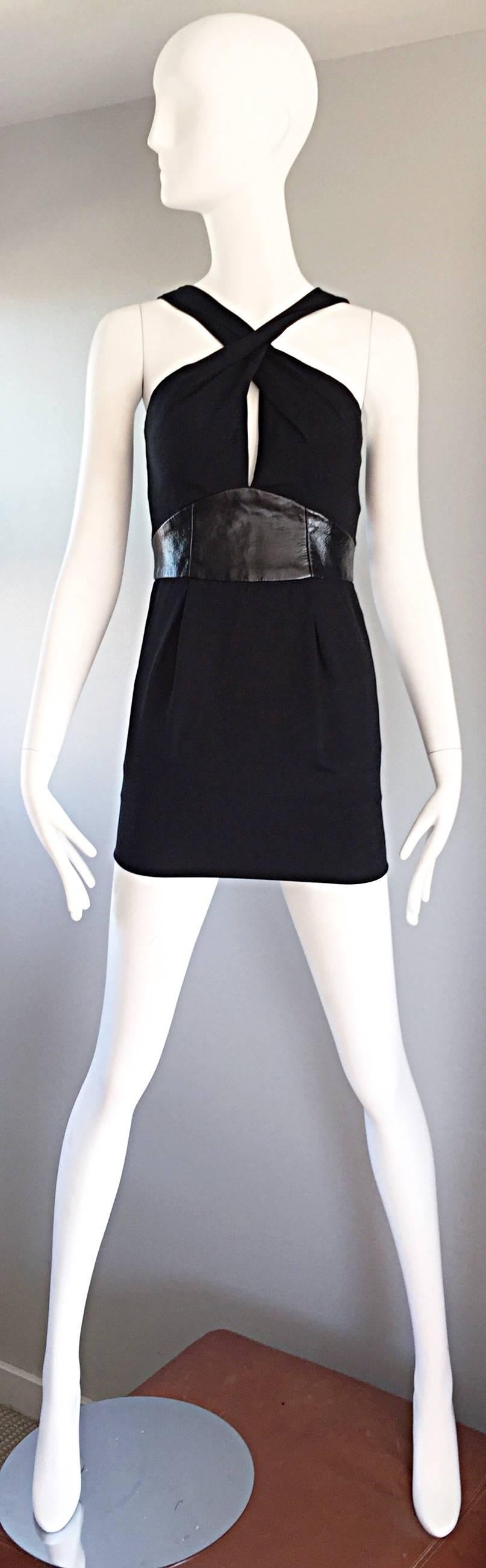Sexy brand new with tags early 2000s BADGLEY MISCHKA black jersey and leather mini dress! Features a leather waistband, with a cut-out at center bust that reveals just the right amount of skin! Figure flattering, with some stretch that hugs the body