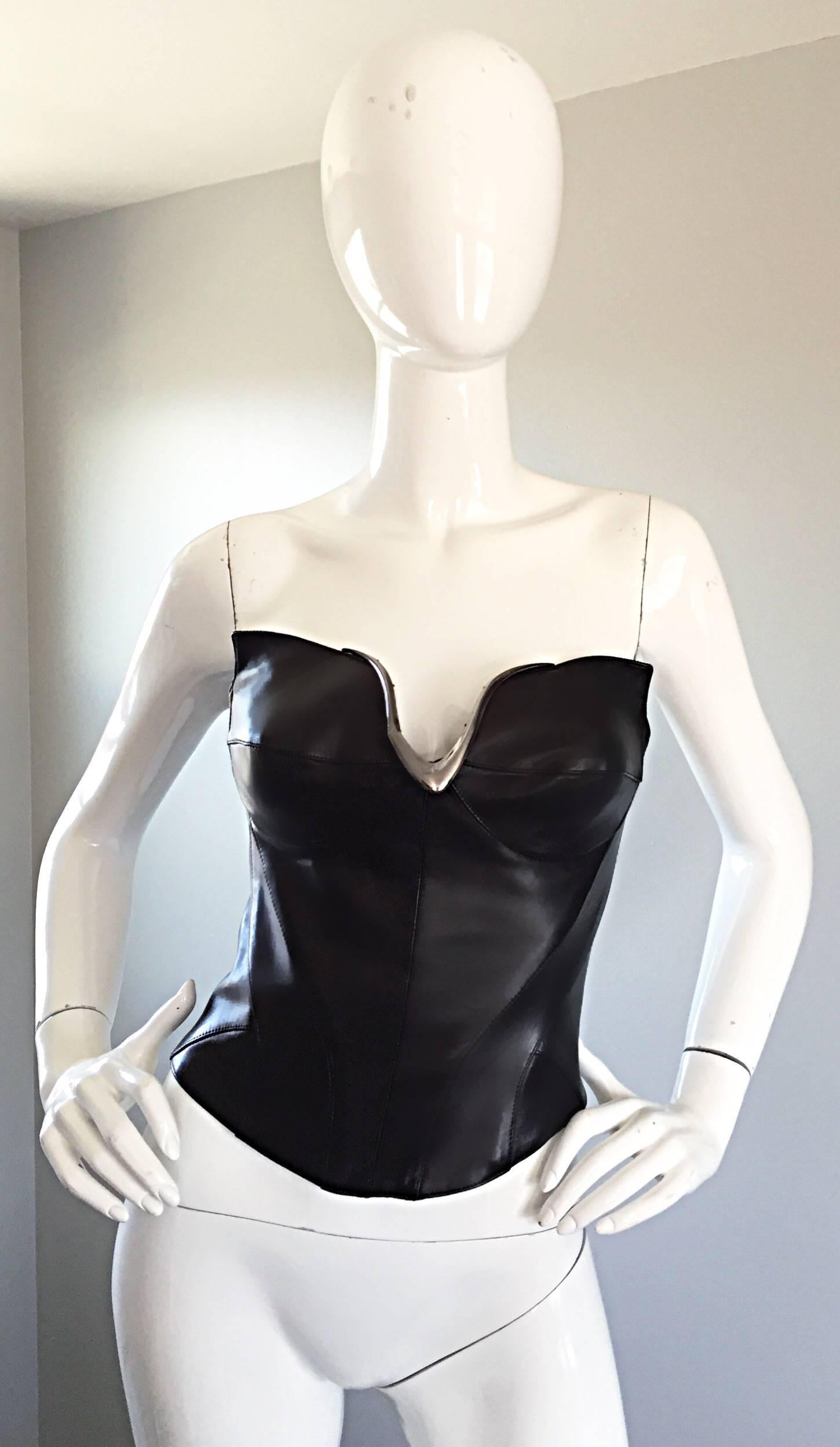 Sexy, rare and iconic vintage THIERRY MUGLER COUTURE black leather Avant Garde bustier corset top! Signature Mugler 'Catwoman' flaps at each side of the bust. Silver metal V at center bust reveals just the right amount of skin. Signature flattering
