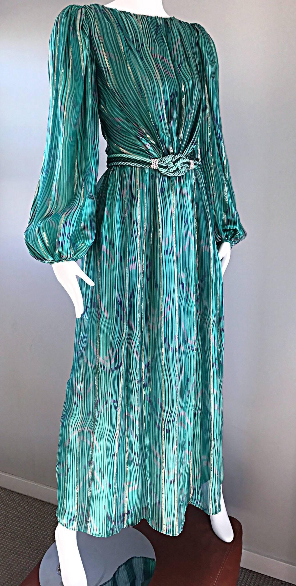 Gorgeous vintage late 70s DIANE DICKINSON silk gown! Features vibrant hues of greens, pink, purple, blue and gold prints throughout. Full Flowy bishop sleeves, with emerald green jeweled button closures at the cuffs. Detachable corded green silk