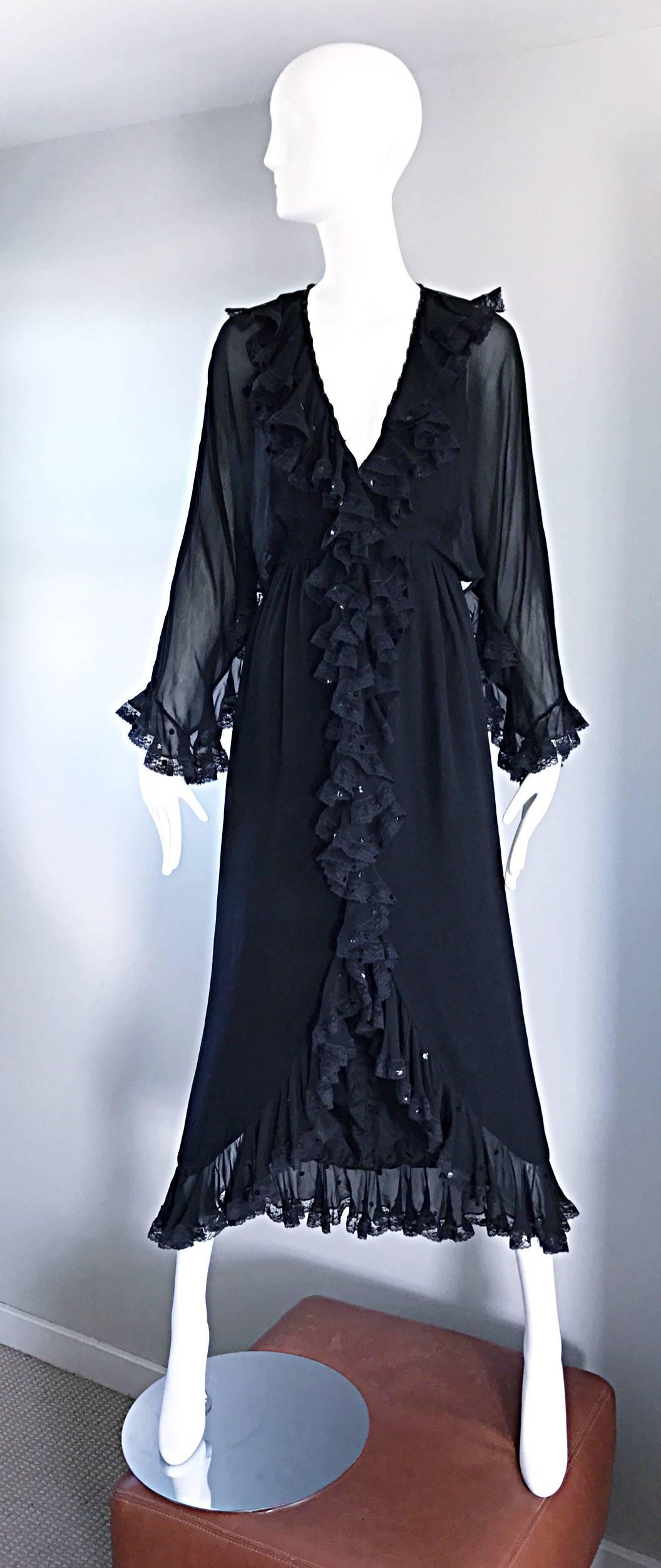 Absolutely beautiful vintage BILL BLASS 1970s black boho evening dress! Features semi sheer dolman sleeves, with chantily lace trim. Matching lace trims the collar and down the center of the dress. Black sequins hand sewn throughout, and intricate
