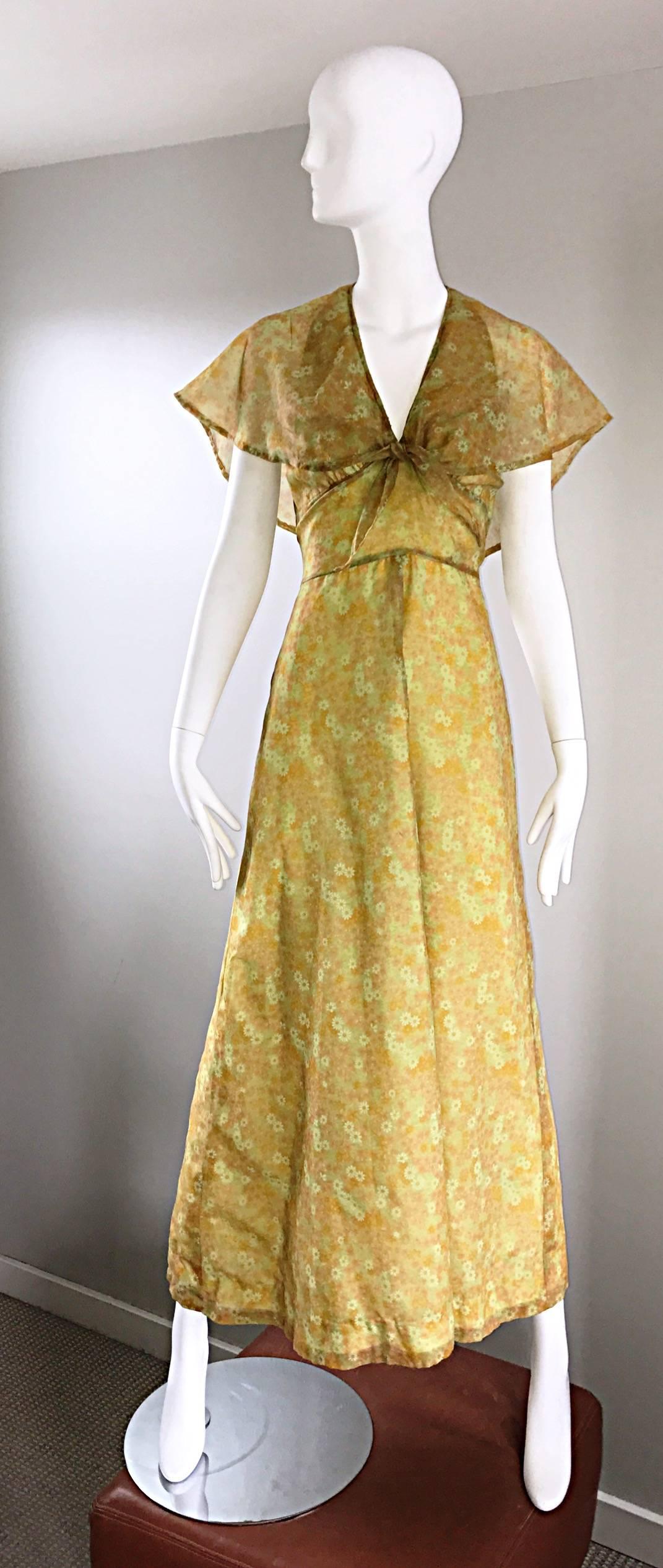 Boho chic 70s yellow and chartreuse green chiffon maxi dress. Features a gorgeous Allover mini Daisy print, with a flowy attached caplet. Cap lets ties at the empire waist, making this beauty accessible to an array of bust sizes. Fitted bodice, with