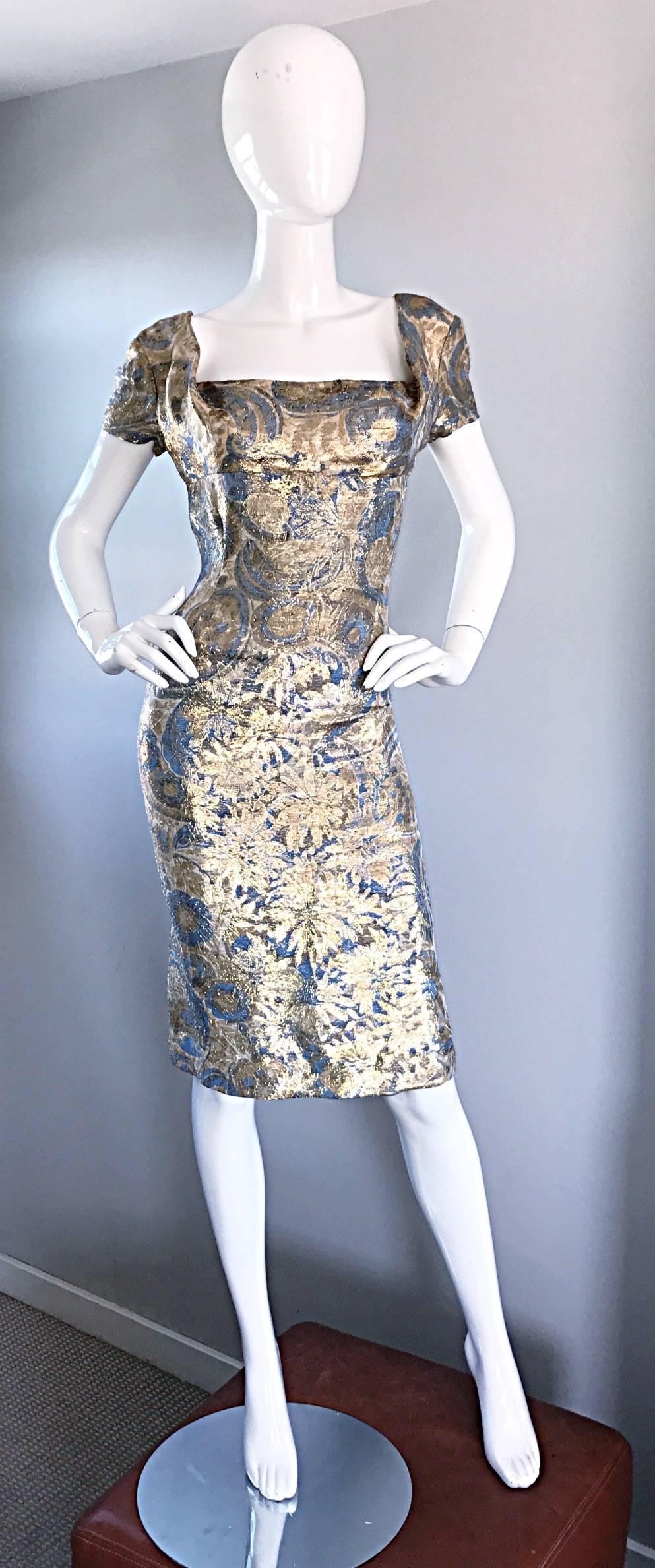 Incredible vintage 1950s PEGGY BARTON Couture blue and gold silk brocade metallic wiggle dress! Features an allover gold and blue metallic regal flower and paisley print throughout. Flattering cap sleeves. Shelf bust can accomodate an array of bust