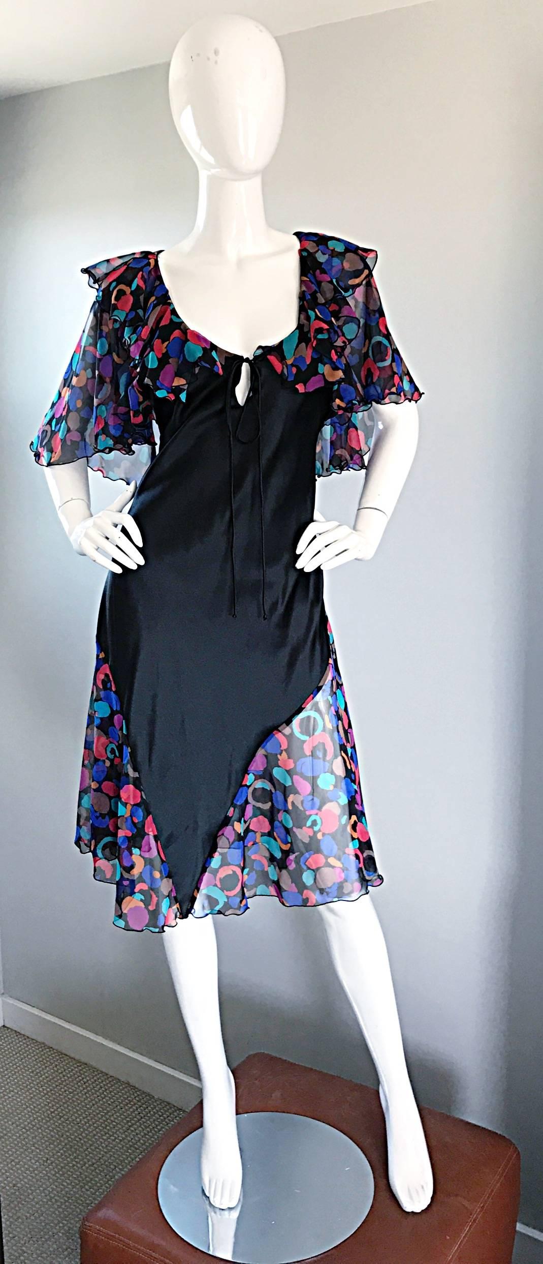 Chic 1980s BOB MACKIE bohemian black and colorful asymmetrical dress! Features a black asymmetrical panel on the front, with a colorful geometric chiffon skirt, sleeves, and semi sheer back. Ties at bust to accomodate an array of sizes. Ruffles at