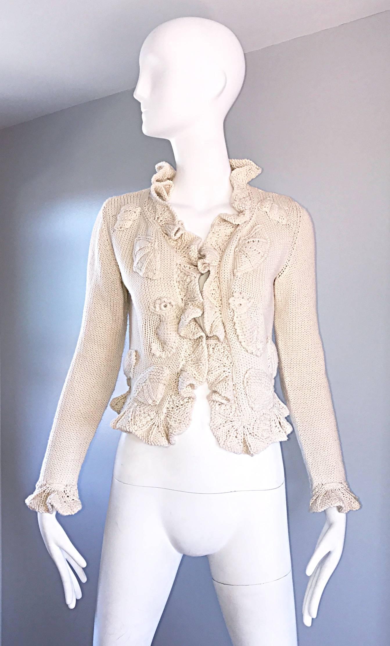 Amazing vntage MOSCHINO COUTURE 1990s off white / ivory novelty cardigan sweater! Features hand embroidered knit sea horses and sea shells throughout the front. Chic Ruffles at the collar, and sleeve cuffs. Super soft thick cotton knit. Incredibly