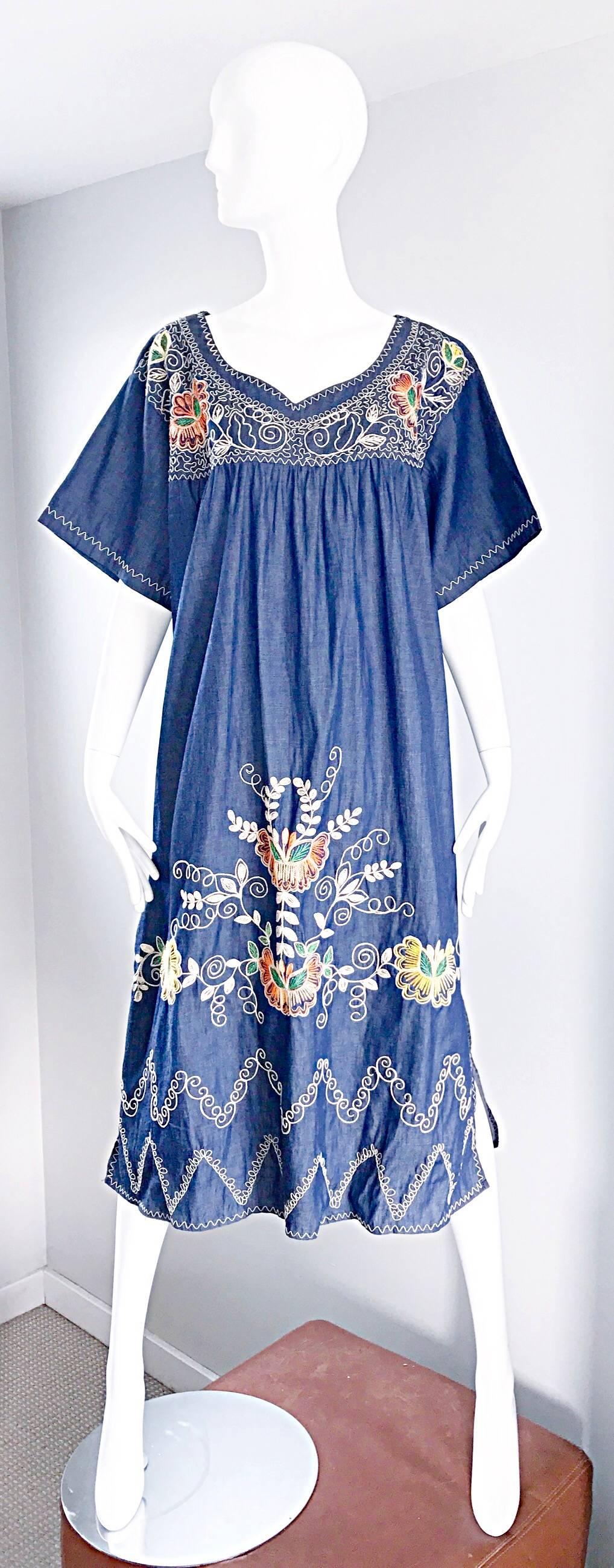 Amazing 1970s lightweight boho cotton denim hand embroidered kaftan dress! Features orange, green, yellow, and white embroidery throughout. Lightweight and soft blue jean / denim material. Intricate pleating at bust. Great belted or alone. Perfect