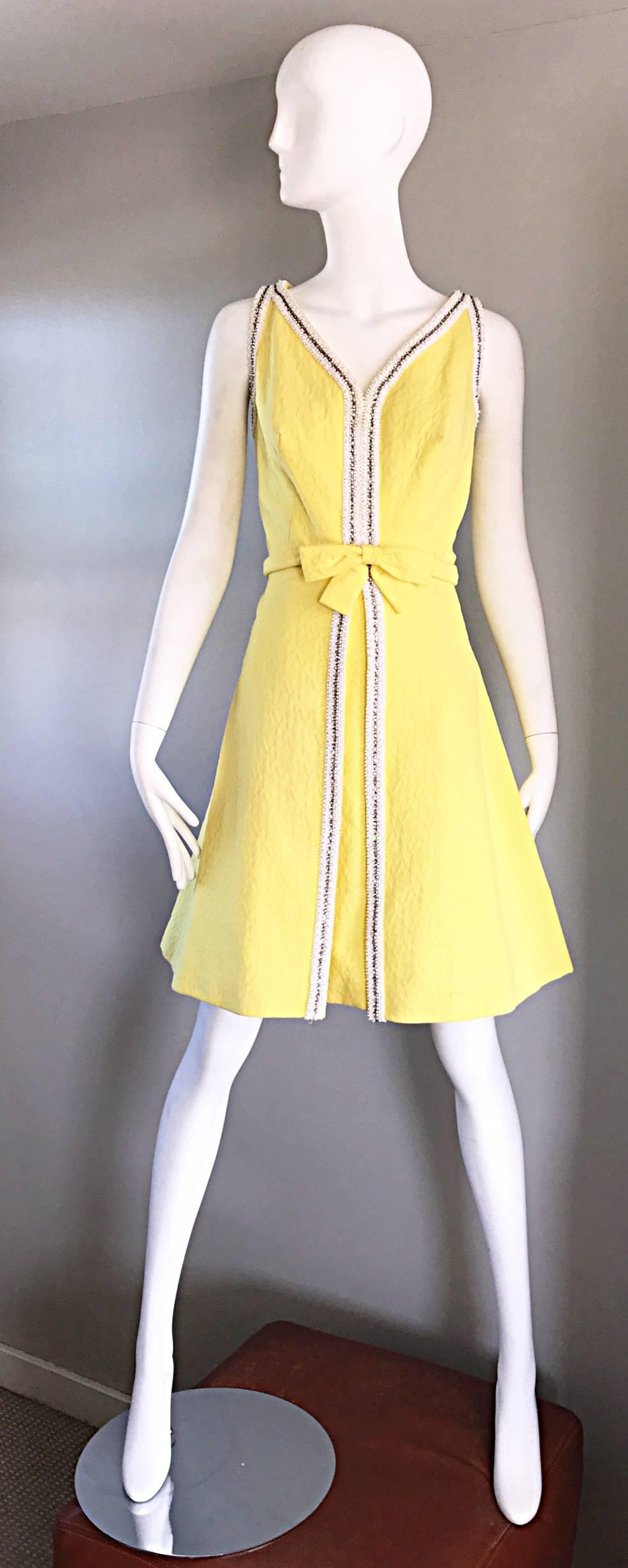 Chic vintage 1960s SEATON ENTERPRISES LTD. Couture canary yellow beaded and rhinestone A-Line dress! Textured yellow cotton rayon blend, with thousands of hand-sewn rhinestones and white beads down the center, and around the collar. Attached bow
