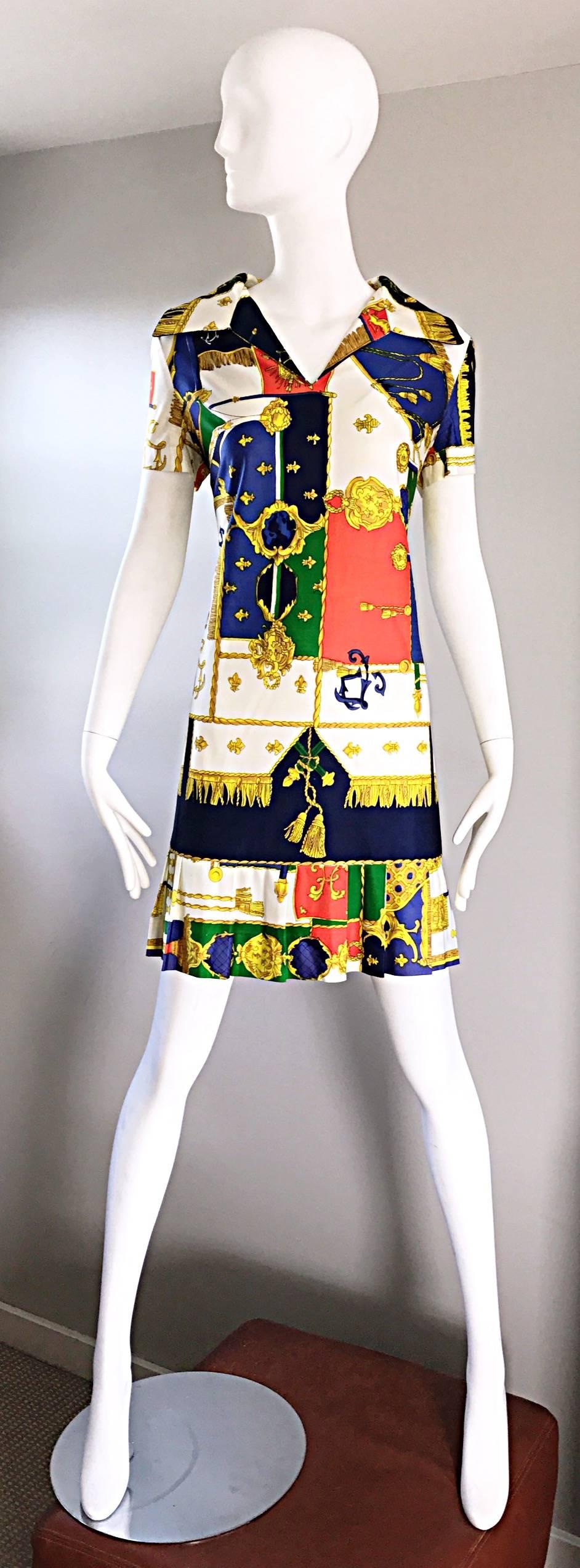 Fantastic vintage 1960s STACY AMES nautical novelty shift shirt dress! Features allover whimsical prints with crests, shields, and rope. Vibrant hues of orange, green, blue, yellow, gold and navy. Chic collar, with a flirty pleated hem. Hidden metal