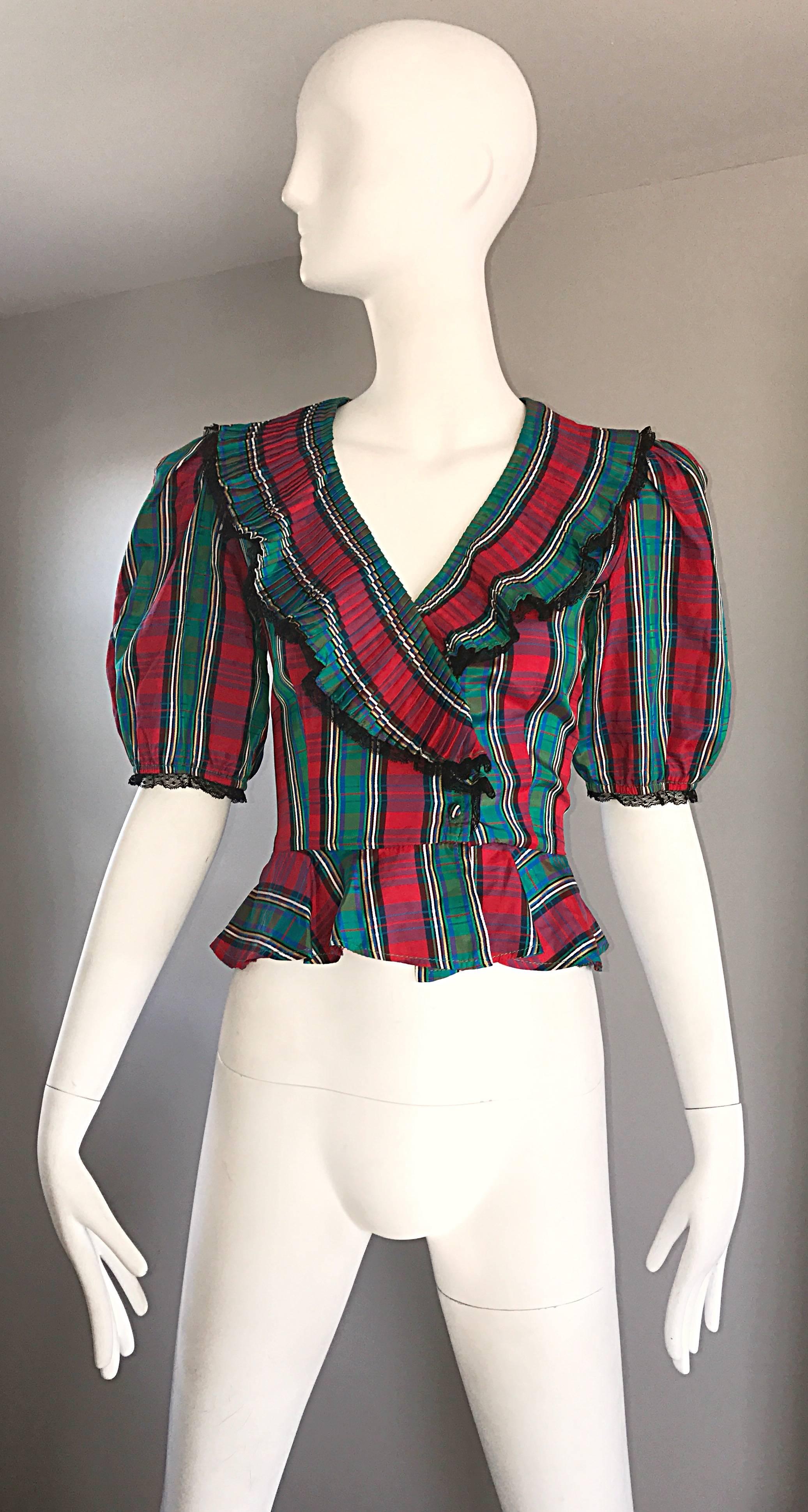 Chic late 70s red and green tartan plaid taffeta 'Victorian Revival' top! Features a fitted bodice, with a peplum waist. Accordion ruffled collar with black lace trim. Stylish full puff sleeves with matching black lace trim. Buttons up the bodice.