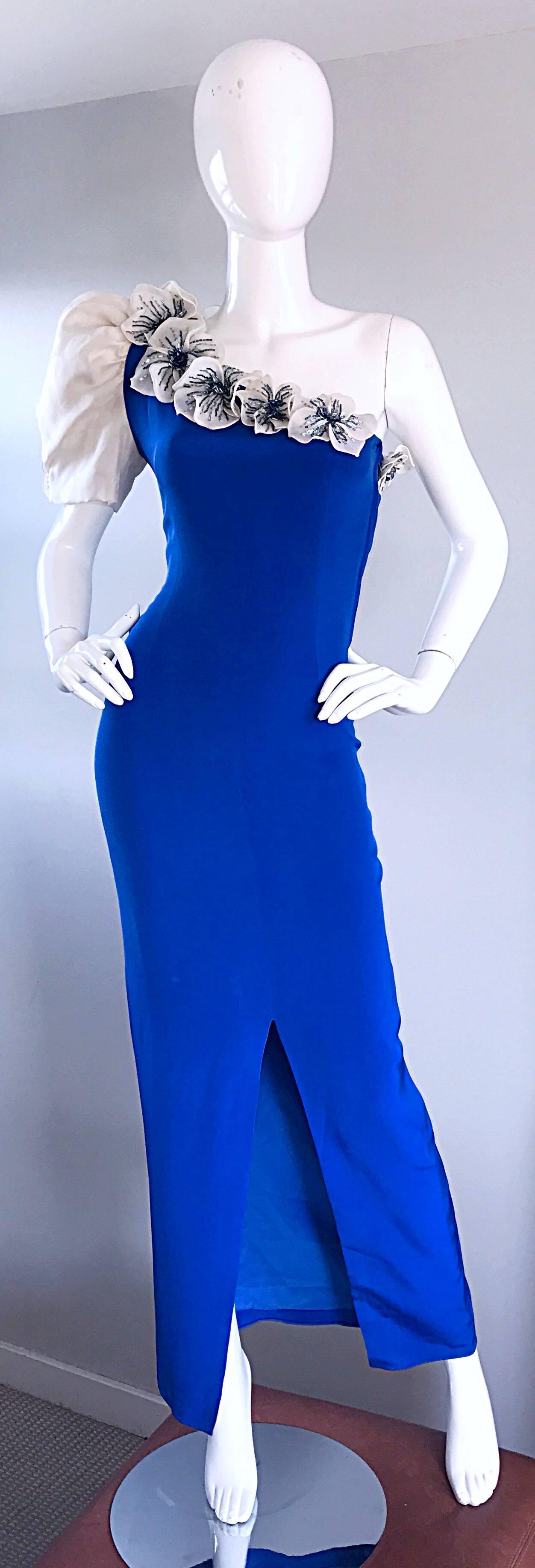 Amazing 1980s vintage MILO Couture vibrant royal blue and white one shoulder double layered silk gown! This 80s gem features a one full shoulder sleeve, with white beaded flower appliqués on the front and back bodice. Flattering form fitting fit