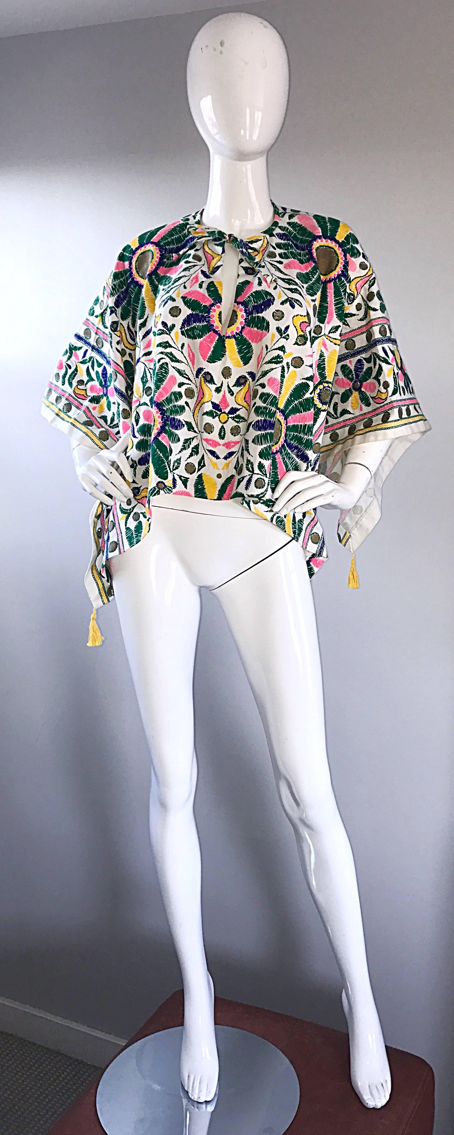 Incredible vintage 1970s hand painted cotton boho poncho / cape! Features colorful birds and flowers throughout in vibrant shades of pink, green, yellow, and blue. Keyhole neck at front center neck, with tie closure. Great with jeans, shorts,
