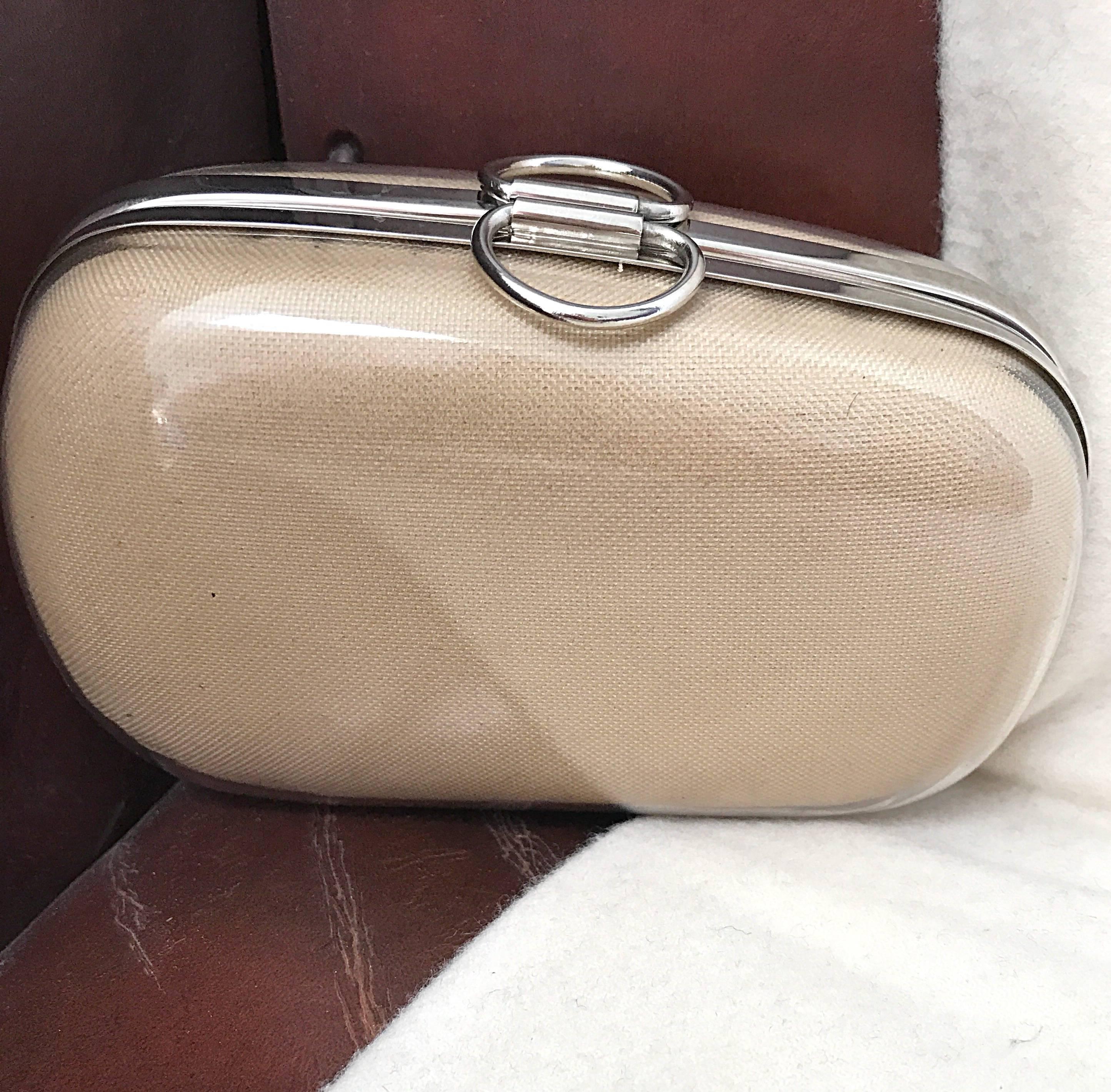 Super chic and rare early 90s ISAAC MIZRAHI nude khaki / tan plexiglass minaudiere clutch! Features the perfect nude tan linen and cotton blend, overlapped with a clear plexiglass. Asymmetrical shape, with two finger loops at top center..Can easily