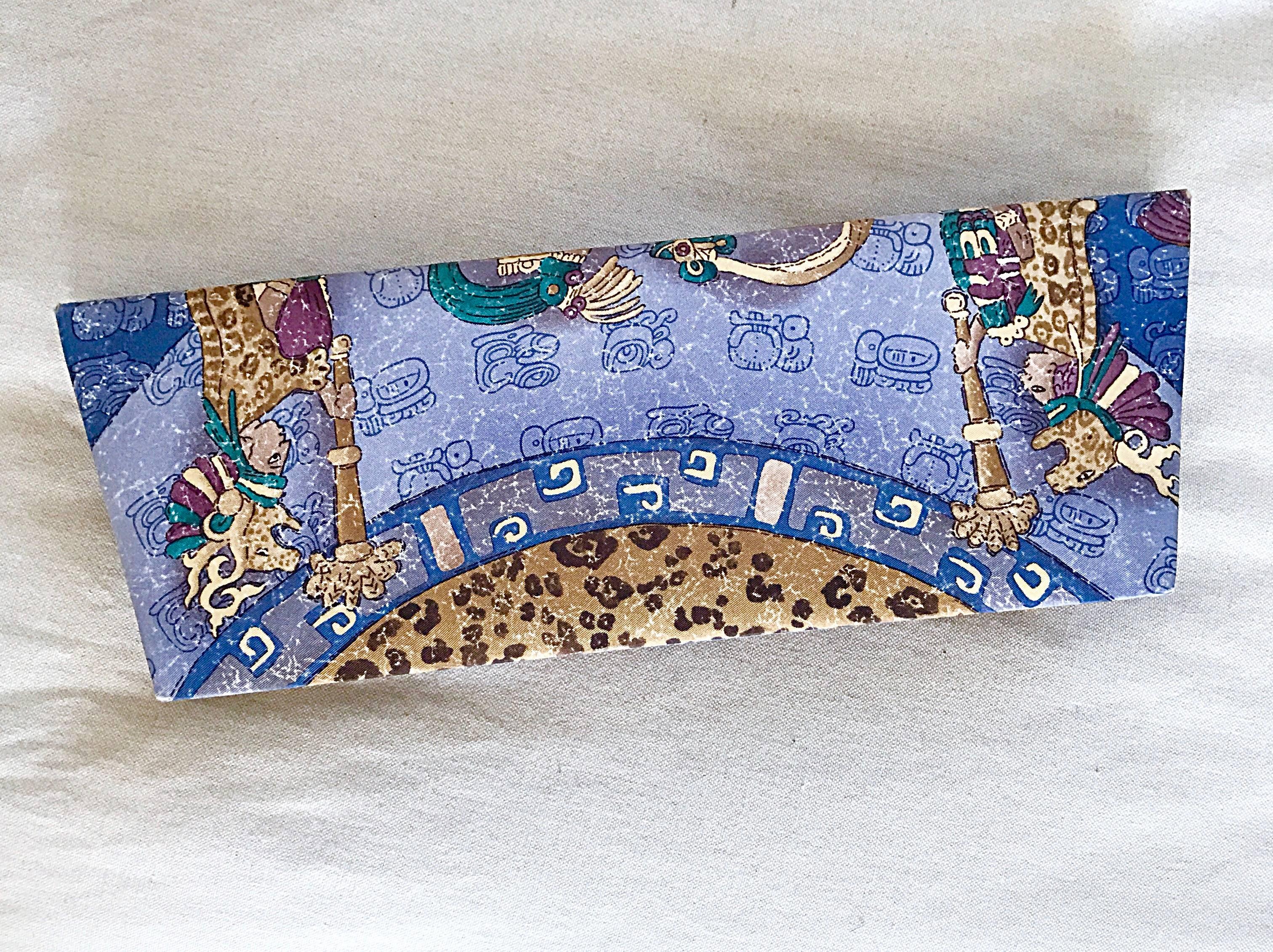 Beautiful vintage PINEDA COVALIN blue silk Aztec / Mexican themed asymmetrical clutch bag! Features Egyptian themed figures, with ornate prints throughout. SLanted shape, with a wider top. Can easily be dressed up or down. Great with jeans or a