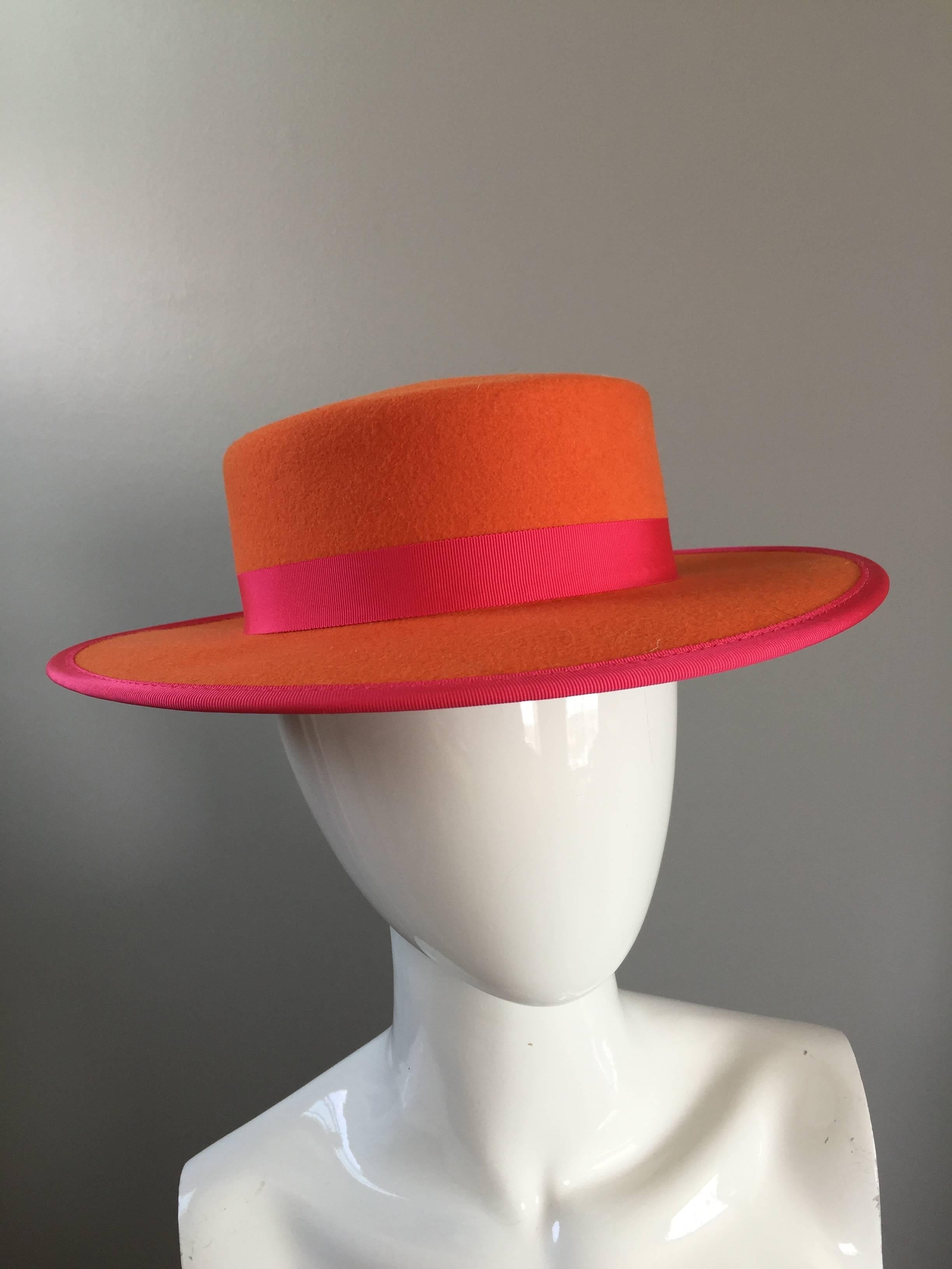 Amazing vintage TINA TOO by the BOLLMAN HAT COMPANY bright orange and hot pink hat! Soft wool doeskin felt. Pink silk grosgrain ribbon around the hat. Can be worn multiple ways, and will fit most head sizes due to shape. Made in USA
Interior
