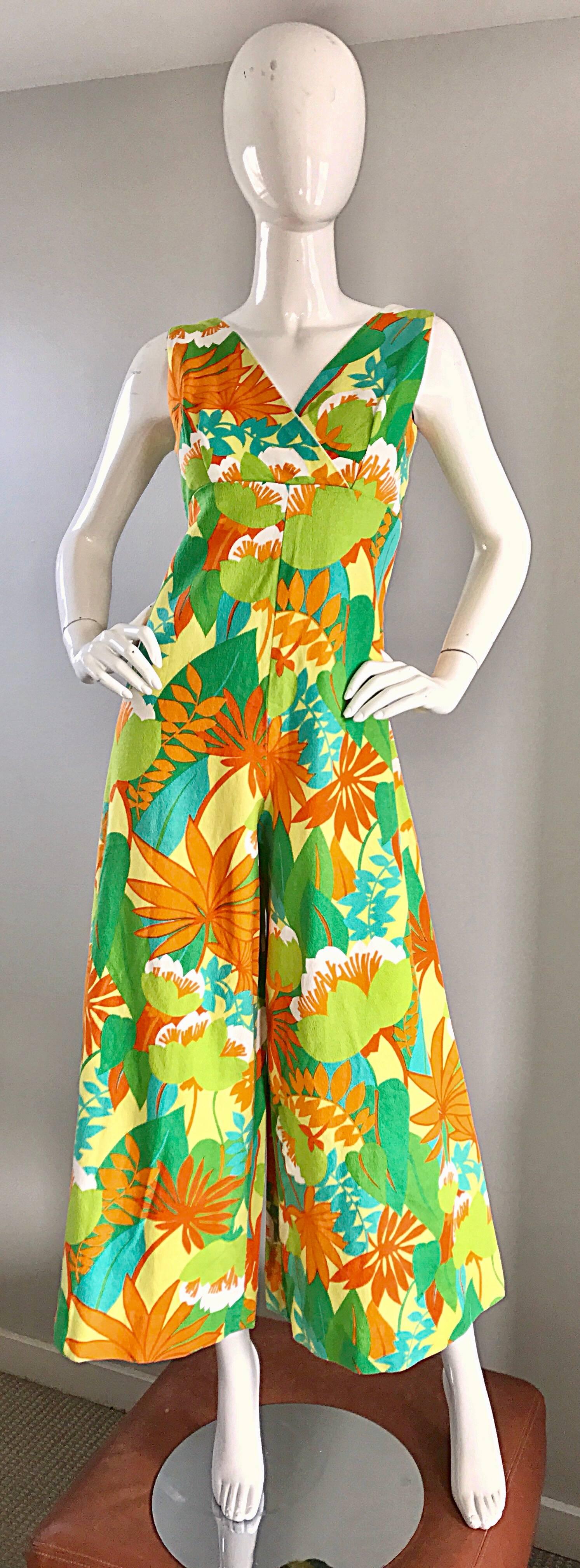 Amazing vintage 1970s neon tropical print wide leg jumpsuit! Features allover tropical prints in bright hues of orange, green, and yellow. Soft cotton holds shape nicely. Full metal zipper up the back with hook-and-eye closure. Great with sandals,