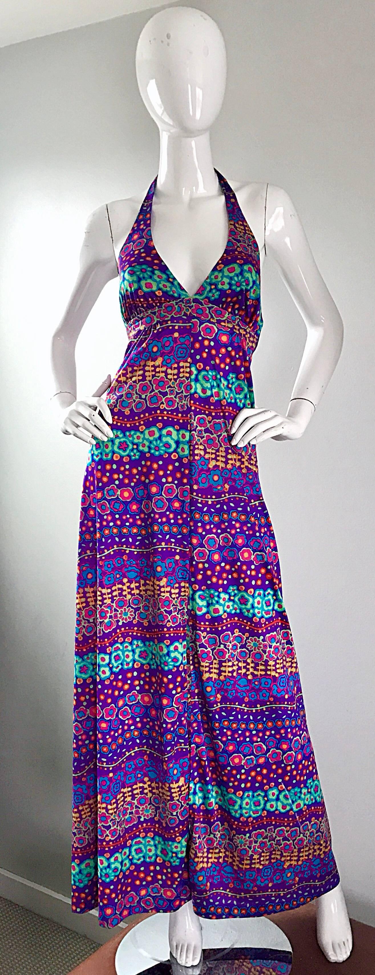 Incredible 1970s halter maxi dress! Features allover prints of flowers in bright vibrant colors. Purple backdrop, with flowers in pink, orange, blue, violet and teal. Hidden zipper up the back, and ties at back top neck. An easy chic gem, that is