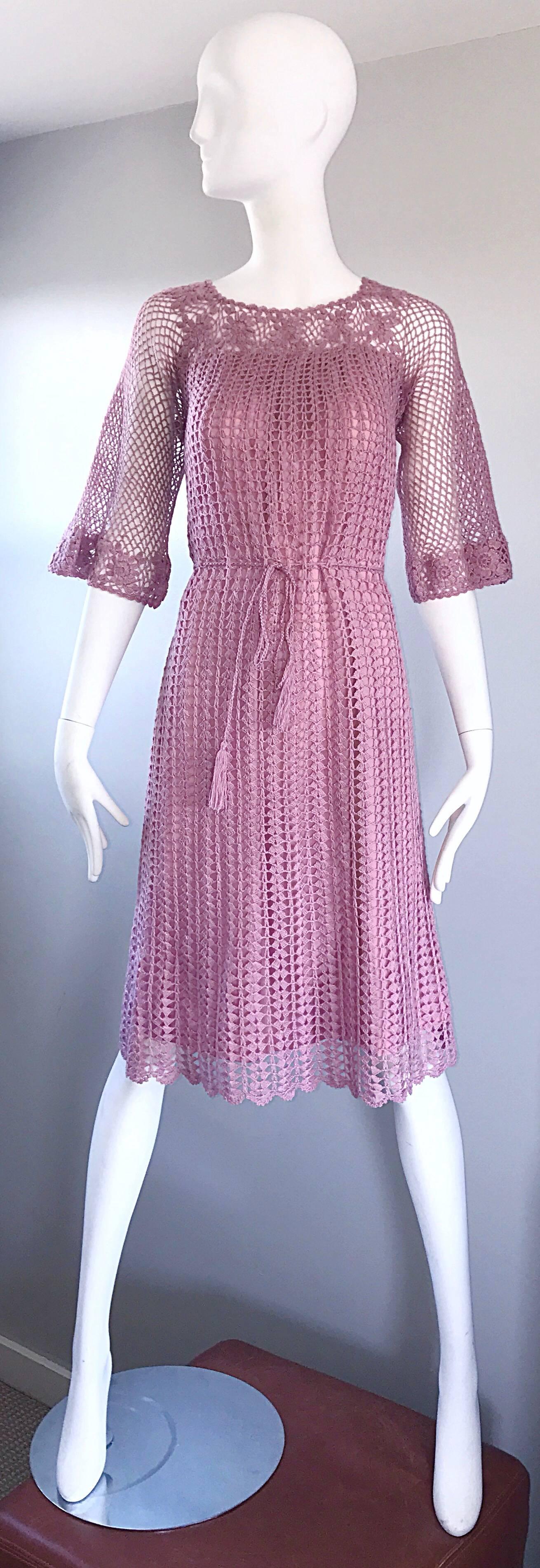 Such a beautiful early 1970s pink / rose colored hand crochet boho dress! Features a tie waist, so can fit an awesome array of sizes! Soft cotton and rayon crochet blend. Bell sleeves look fantastic on. Flower crochet detail at neck and sleeve