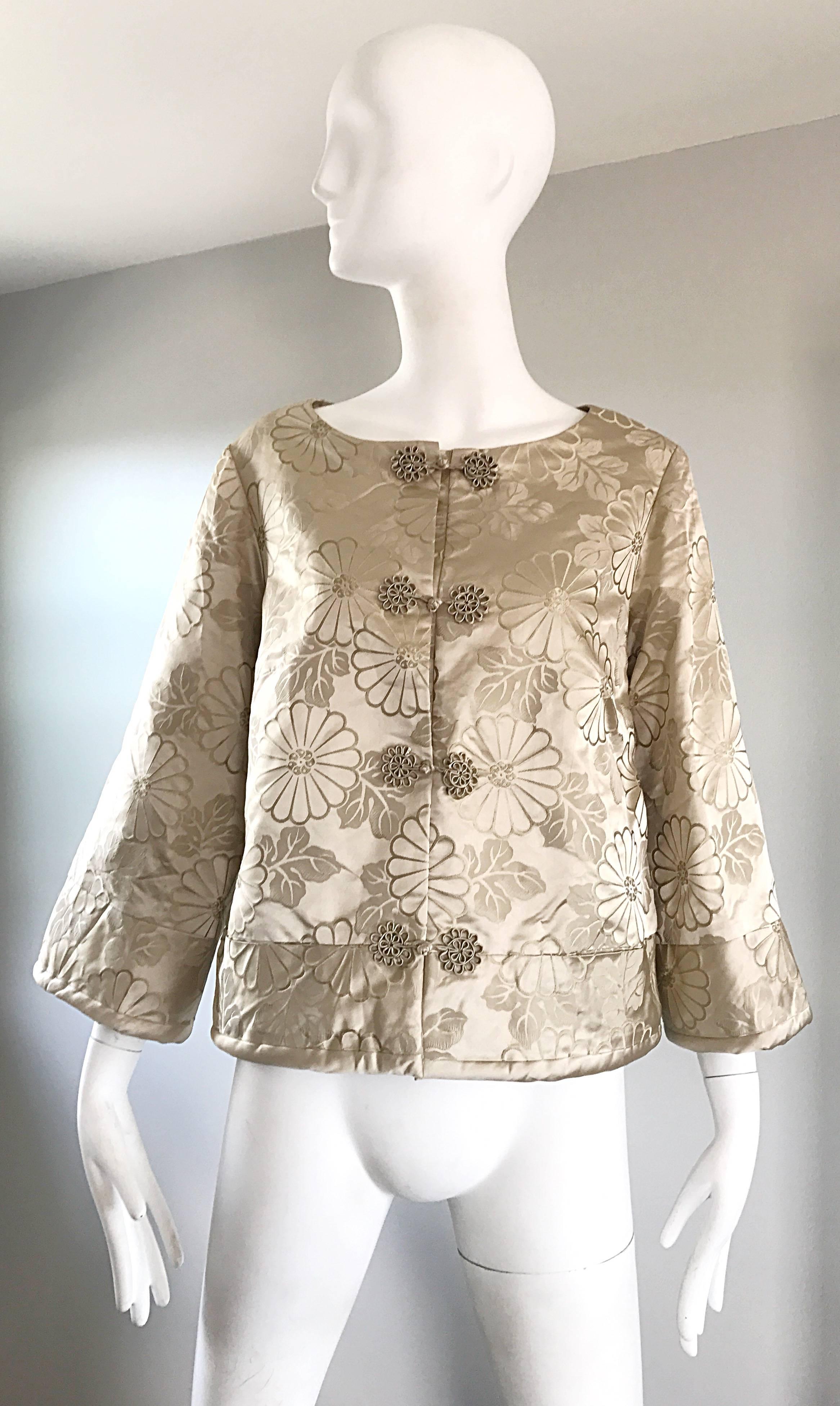 ¡Impresionante chaqueta columpio asiática de seda beige DYNASTY de los años 60! La lujosa y suave seda mantiene muy bien la forma. Elegantes mangas de campana. Botones de seda anudados en el corpiño. Tiene un bolsillo a cada lado de la cintura. Se