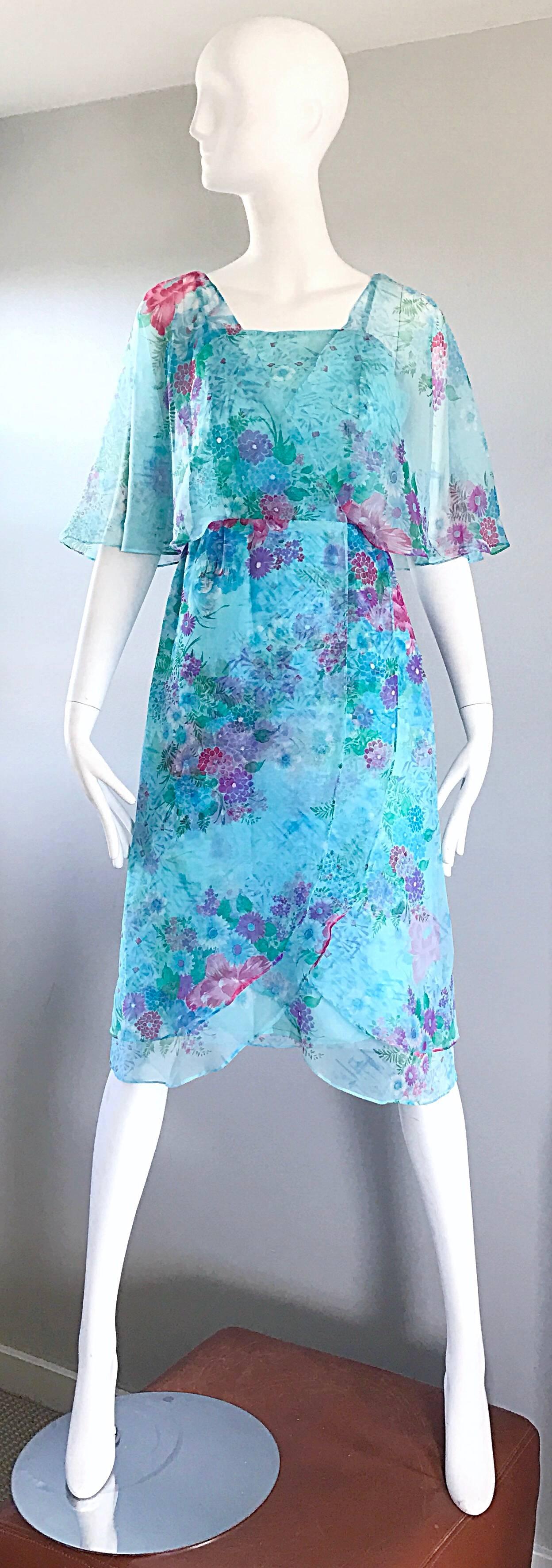 Gorgeous 1970s JANE ANDRES for GUMPS OF SAN FRANCISCO blue chiffon boho flower dress! Flirty and fun, with a beautiful floral print throughout. Vibrant blue, with bright pops of purple, pink and green flowers throughout. Flowy chiffon sleeves. Full