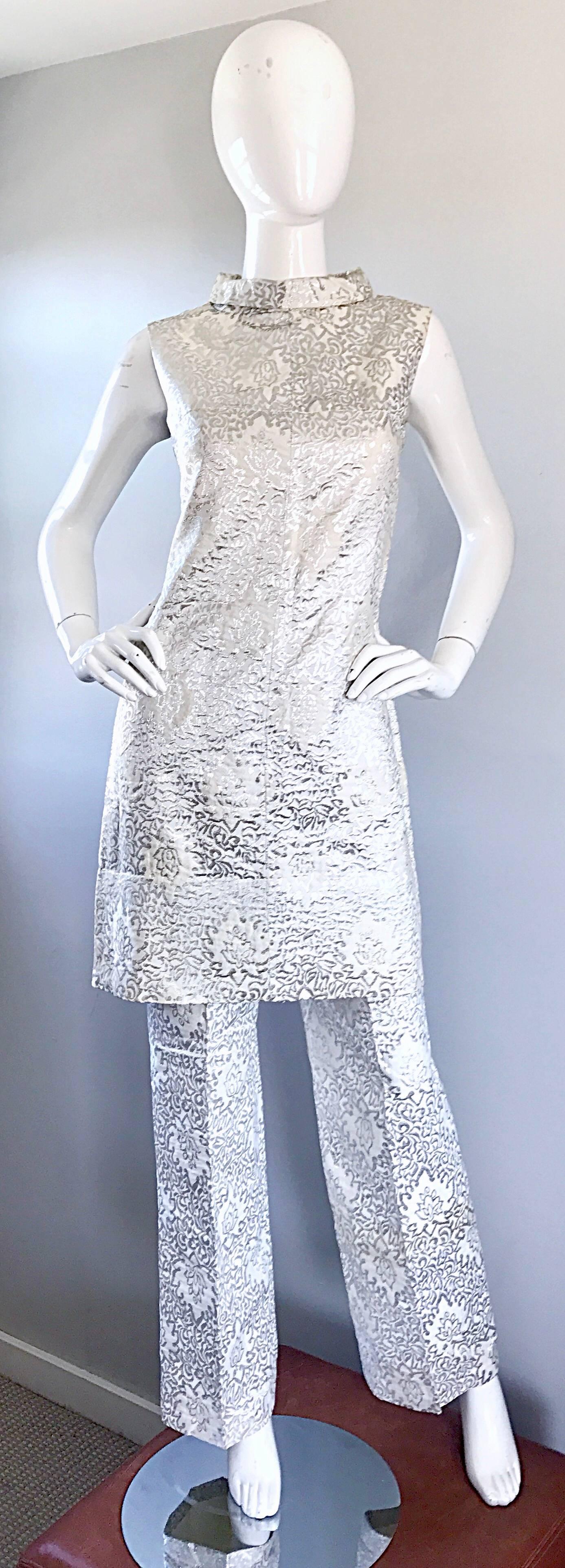 Smashing 1960s silver and white silk jacquard tunic dress AND trousers! Features a mod shift tunic dress, with a fitted bodice and full skirt. High 
Jackie-O styled collar. Full metal zipper up the back with hook-and-eye closure. Pants are high