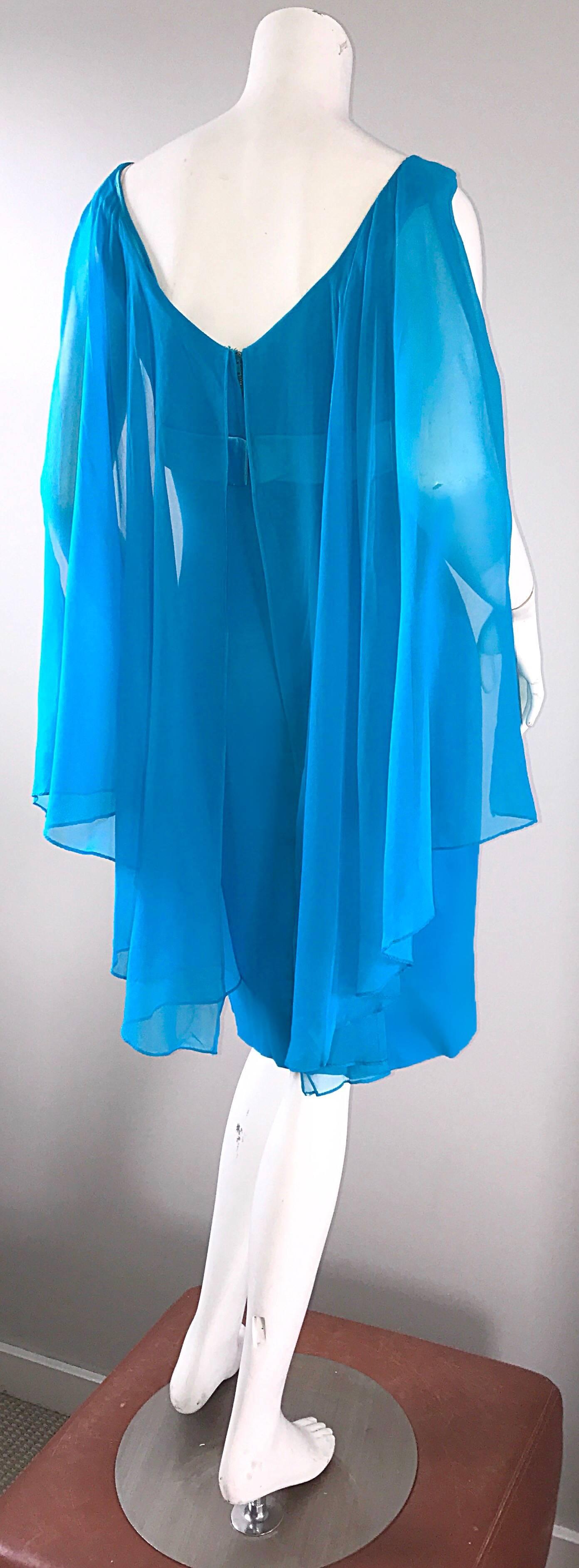 Incredible vintage early 1960s turquoise / teal blue chiffon wiggle dress, with attached chiffon caplet! Wonderful flattering fit, with heavy attention to detail. Attached bow belt features three blue rosettes with leaves. Attached cape breaks down