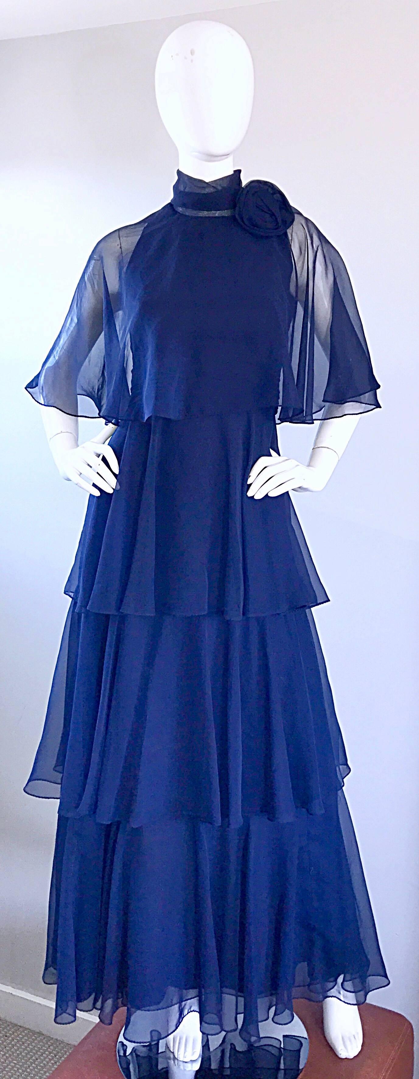 Gorgeous 70s vintage ELLIETTE LEWIS navy blue chiffon high neck tiered ruffle gown! Features three tiers of chiffon, with an attached chiffon caplet. Chiffon rosette at side neck. Full metal zipper up the back with hook-and-eye closure. Looks