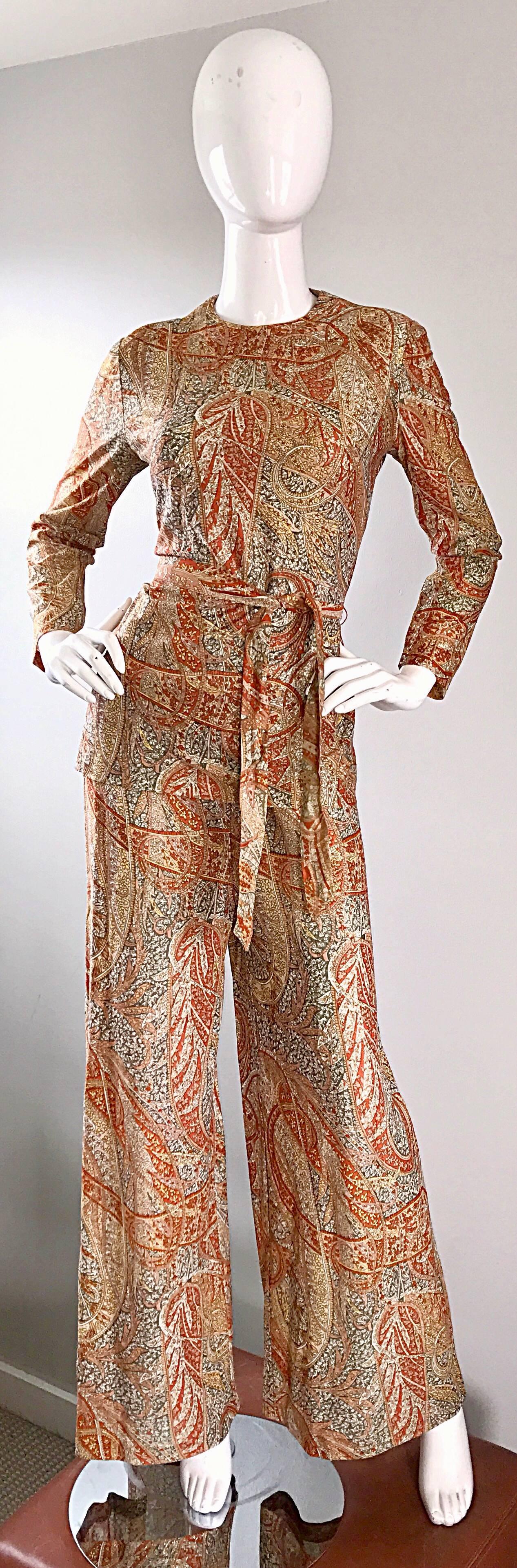 Amazing three piece metallic lurex blend paisley ensemble, including a tunic, belt and wide leg bell bottoms! Features warm tones of brown, burnt orange, tan and gold. Sash belt is detachable from the top. Half zipper up the back of the tunic.