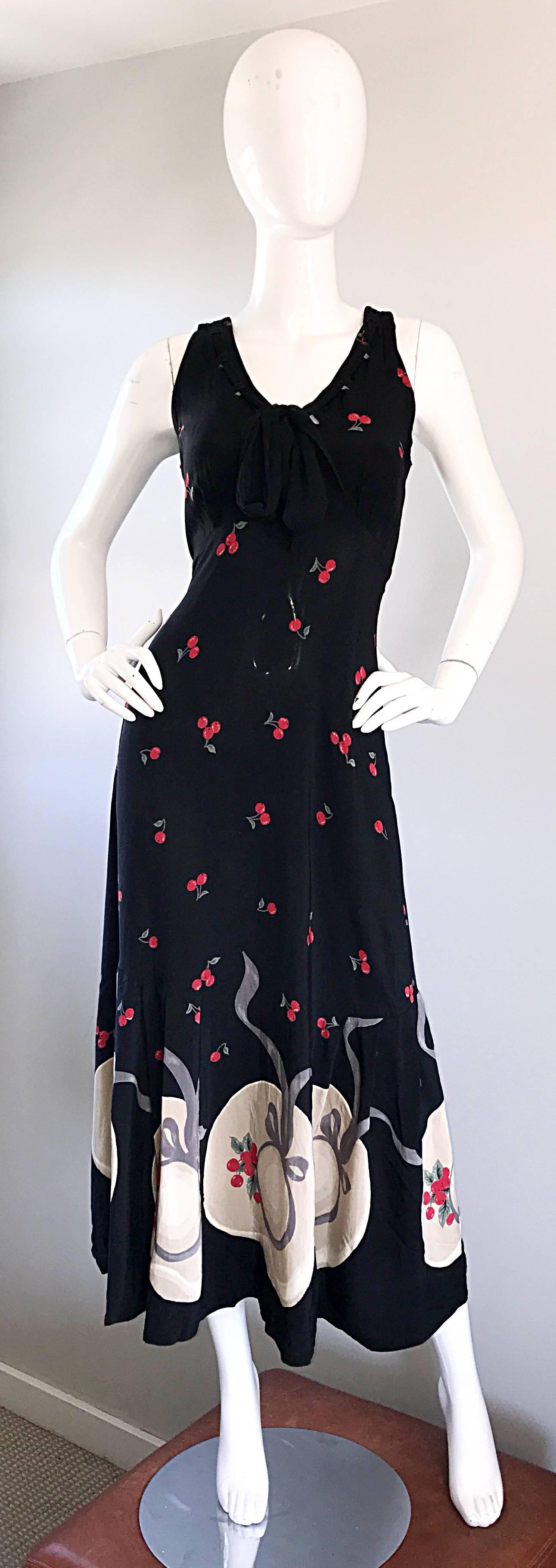 Chic 1990s KAREN ALEXANDER black, red, green, taupe and ivory cherry and hat printed novelty sleeveless maxi dress. Features cherries printed throughout the dress, with ivory and taupe sun hats at the hem. Super soft rayon. Black laces at bust ties