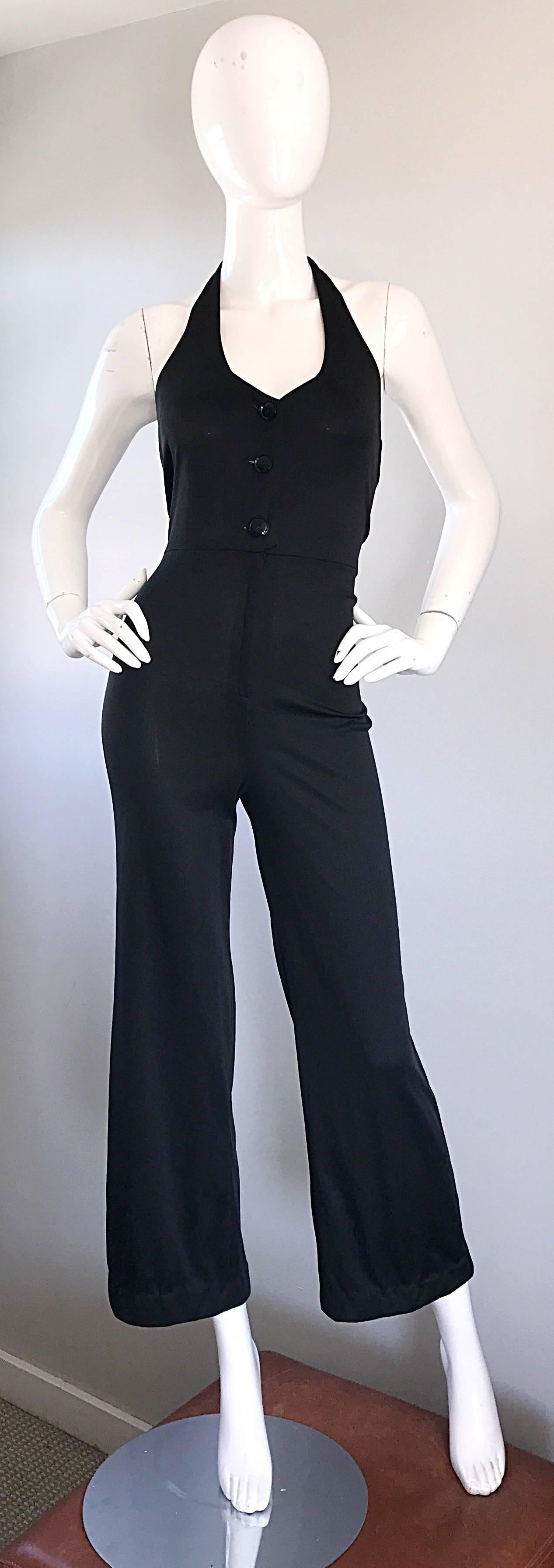 Sexy vintage 70s black jersey halter jumpsuit! Features a tailored bodice that buttons up the front. Hidden zipper at waistband. Nice flare legged / bell bottom. Buttons at back center halterneck. Looks amazing on, and hugs the body in all the right