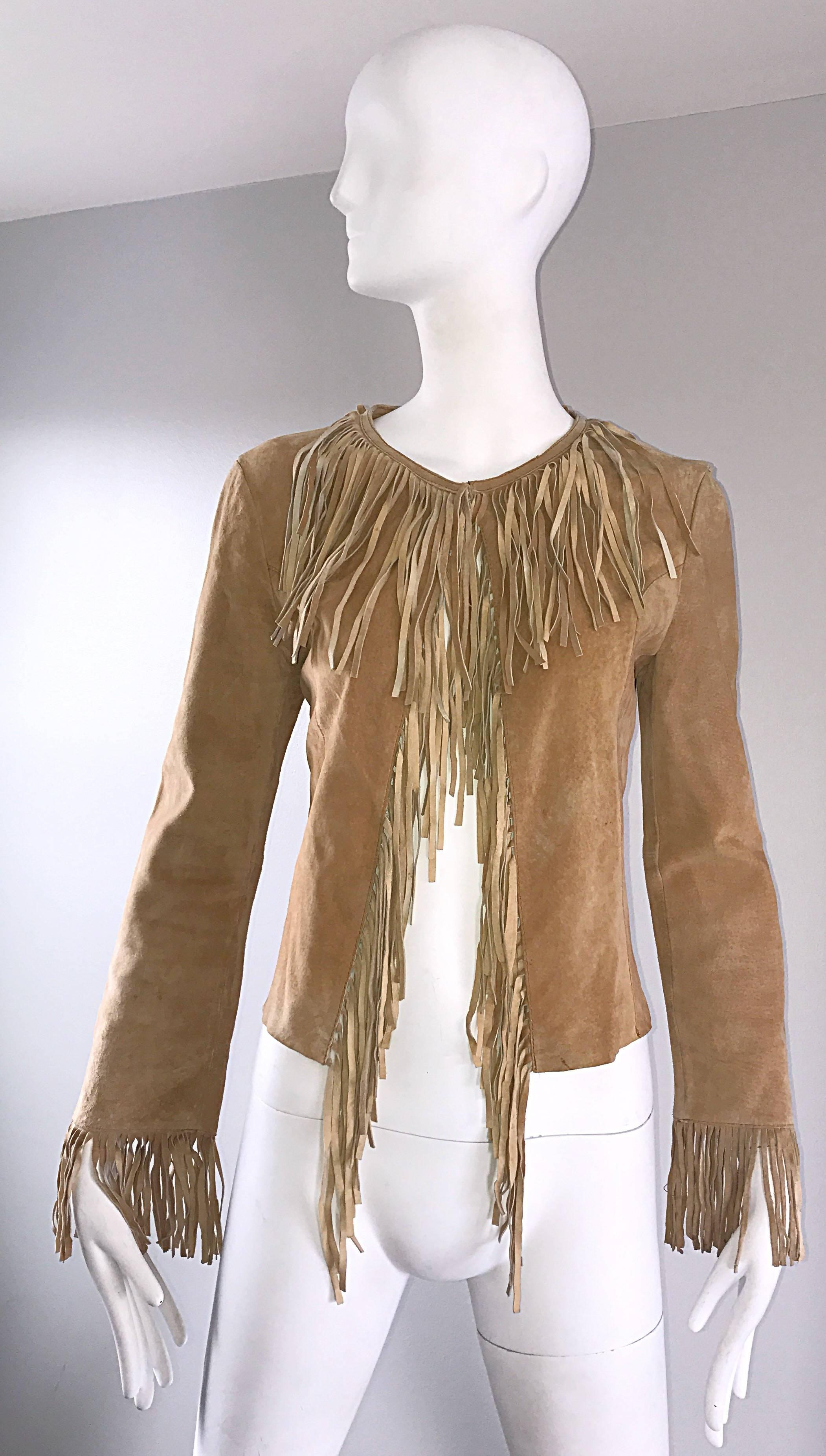 Awesome 1970s tan leather suede fringe jacket! Features fringe at the collar that leads all the way down the front center, and fringe at each sleeve cuff. Looks amazing on (there is so much movement!). Single hook-and-eye closure at top neck. Such a