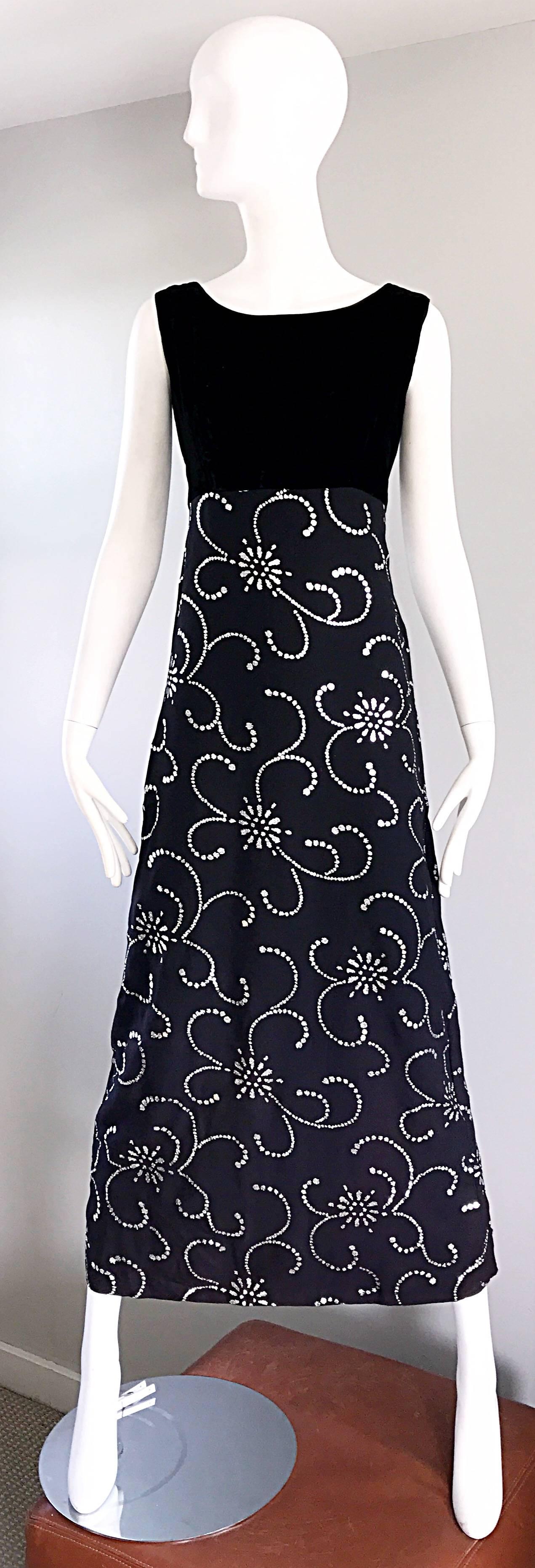 Gorgeous early 1970s black and silver glitter maxi dress or gown! Features a fitted black silk velvet bodice, with a rayon crepe full skirt. Silver glitter throughout creates a wonderful symmetrical print. Slit up the center back hem reveals just