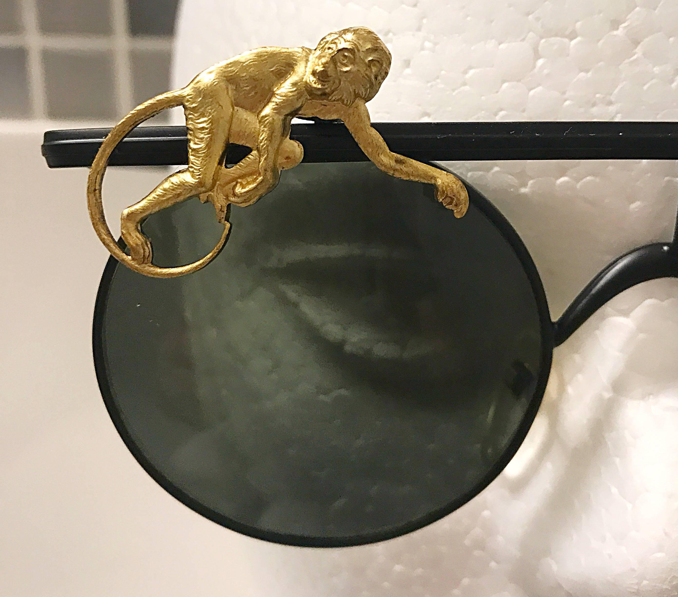 Amazing and super rare 90s MERCURA unisex novelty 'flying monkeys' black and gold round sunglasses! Mercura sunglasses are highly sought after, and are extremely hard to find! Features a black metal bar above the rim of the glasses with a gold
