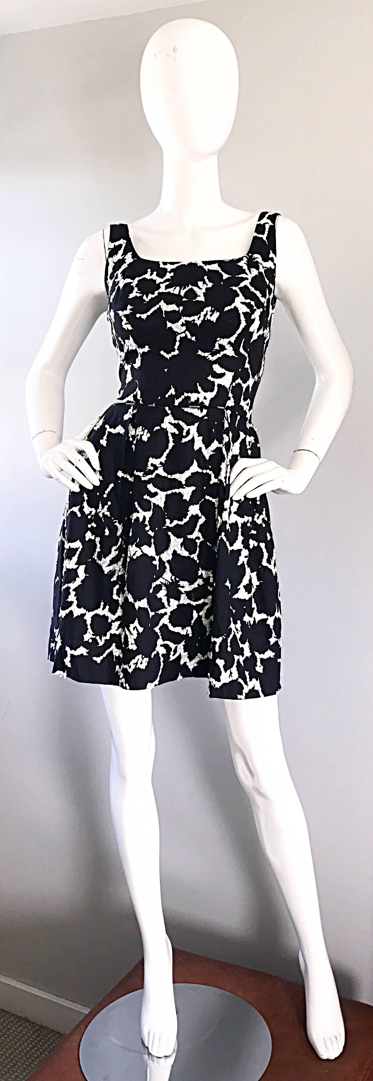 Beautiful vintage 50s black and white leaf print fit n' flare mini dress! Features a white background that is embelished with thousands of hand-sewn white sequins throughout. Fitted tailored bodice with a full skirt. Full metal zipper up the back