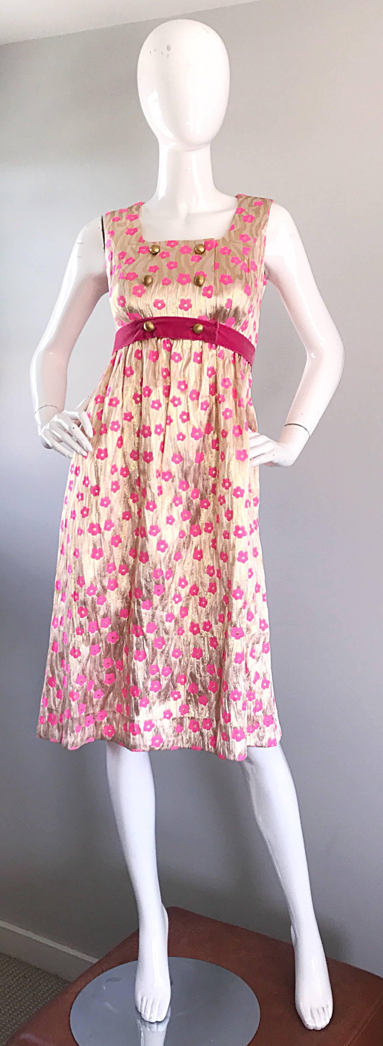 Amazing 1960s metallic gold and pink poppy flower print A-Line dress! Features gold metallic silk with hot pink poppies throughout. Six gold mock buttons on the bodice. Attached pink velvet wrap around belt snaps at side waist. Perfect tea length is
