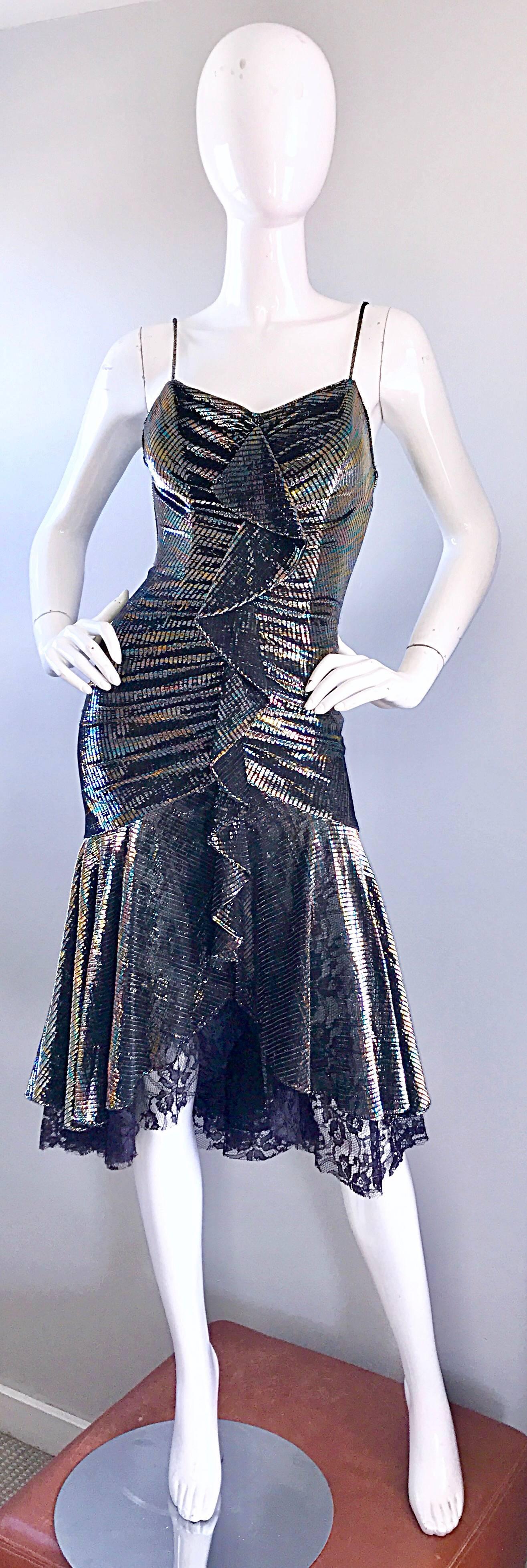 Amazing late 1970s SAMIR Studio 54 rainbow metallic disco dress! Features flattering ruched detail, with an origami ruffle detail up the front center. Asymmetrical handkerchief hem with black lace that peeps through. Boned bodice keeps everything in
