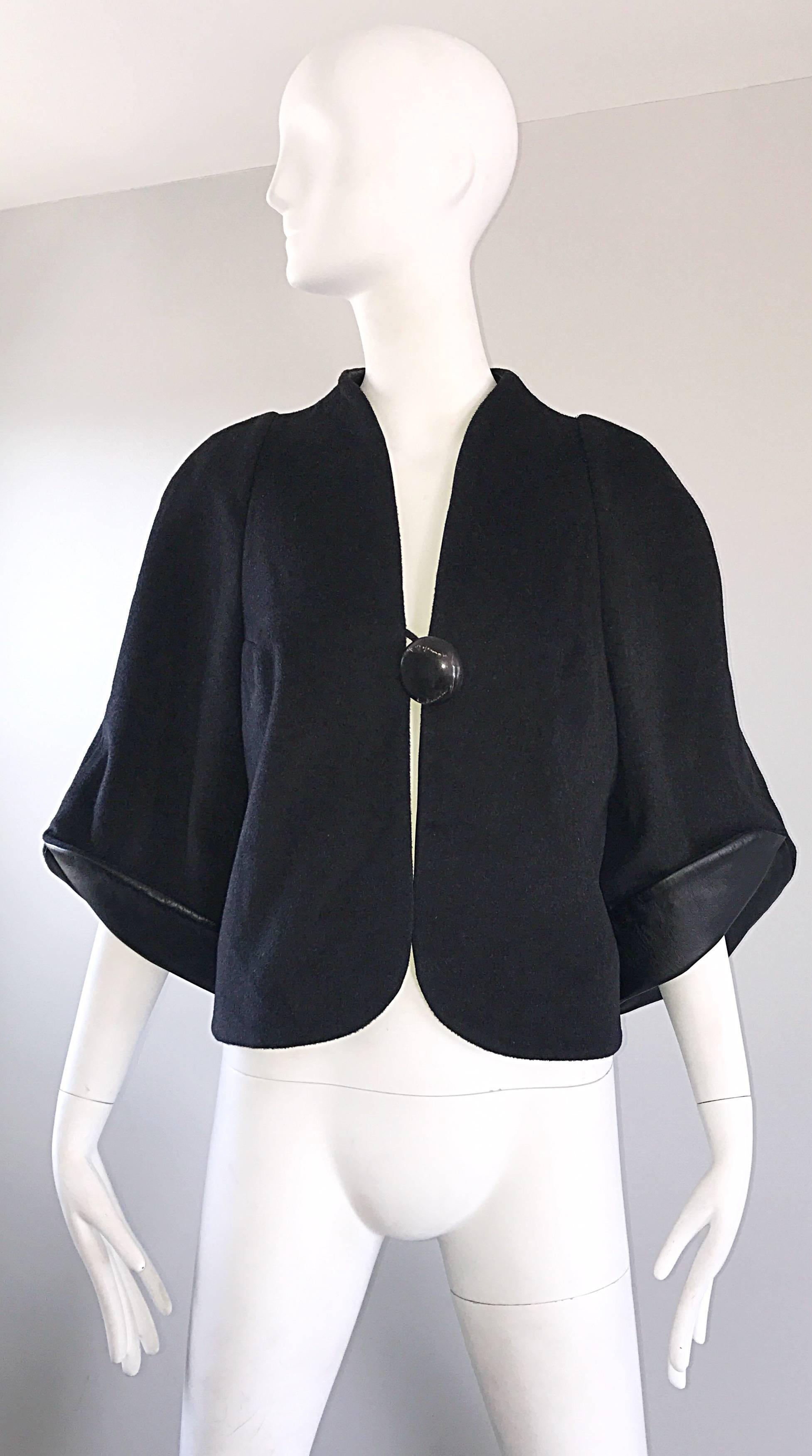 Spectacular brand new RUBIN SINGER black cashmere, wool, and leather cropped swing jacket! Features a singular oversized black marbleized button below the bust. Wide bell sleeves, with soft black lambskin leather under the sleeve cuffs that can be