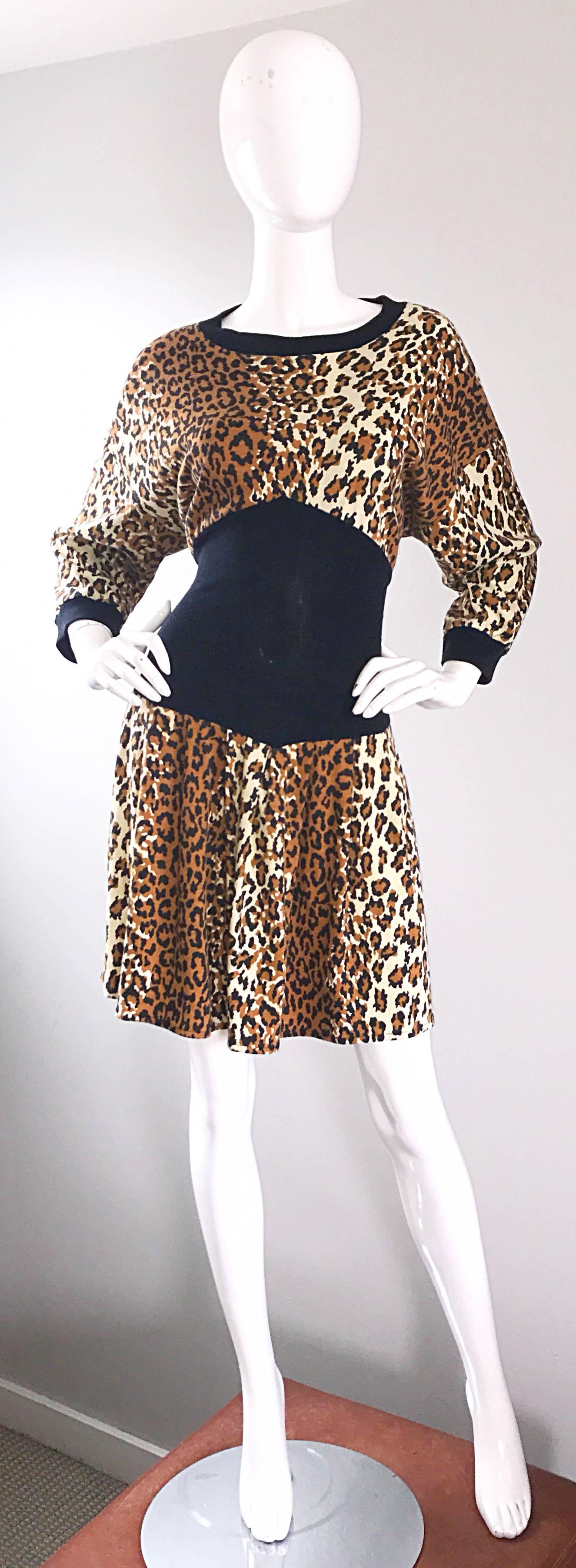 Incredible 1980s leopard / cheetah animal print and black fit and flare cotton sweatshirt dress! Features an allover animal print in tan, brown, ivory and black throughout. Chic dolman sleeves can accomodate an array of sizes. Flattering black