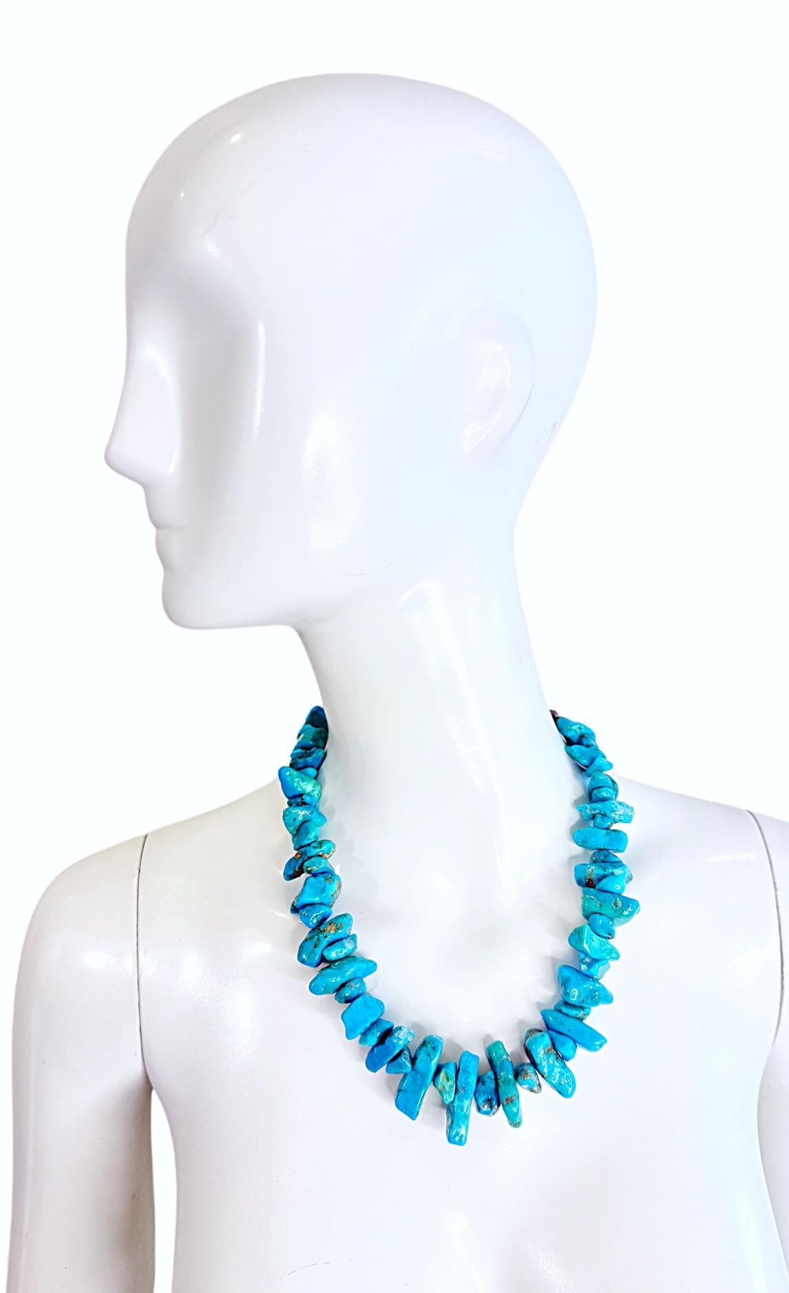 Este llamativo collar navajo vintage de los años 70 presenta atrevidas pepitas de turquesa seleccionadas a mano en ricos tonos azul cielo y verde azulado, cada una de las cuales muestra una matriz natural y una forma orgánica. El peso total del