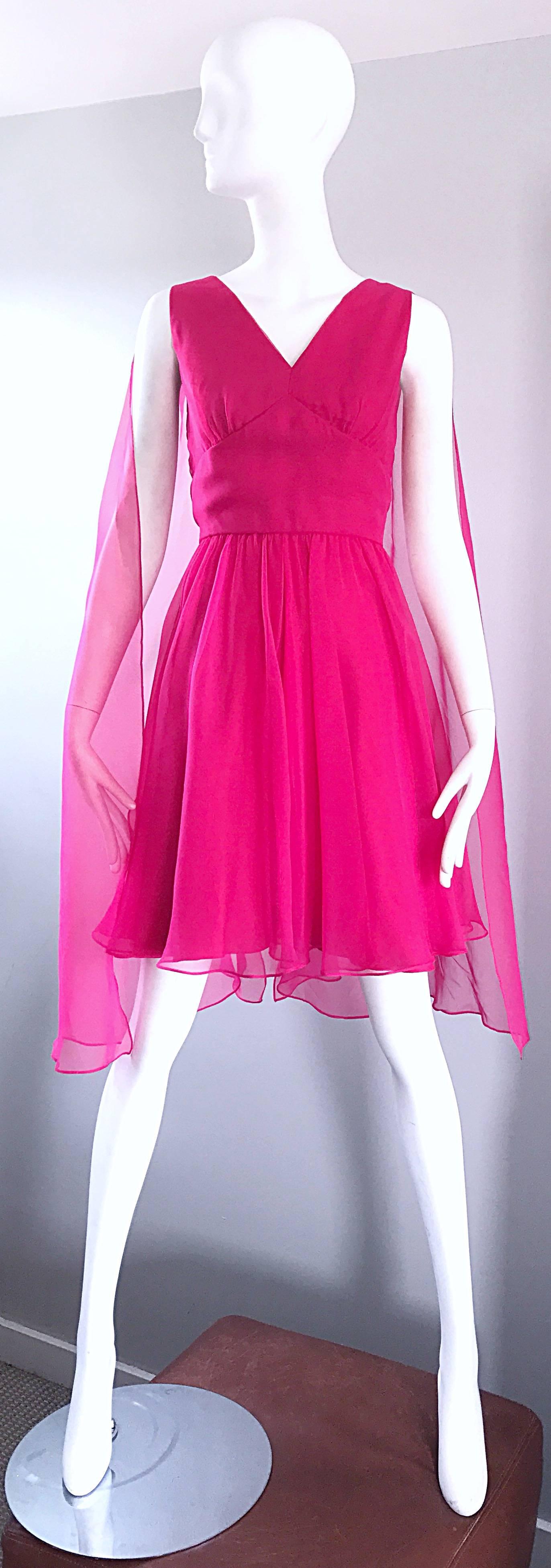 Incredible 1960 hot pink chiffon dress with attached semi sheer chiffon cape! Features a form fitting bodice with flattering and flirty skirt. Hidden zipper up the back with hook-and-eye closure. Looks amazing on, especially with movement. Works
