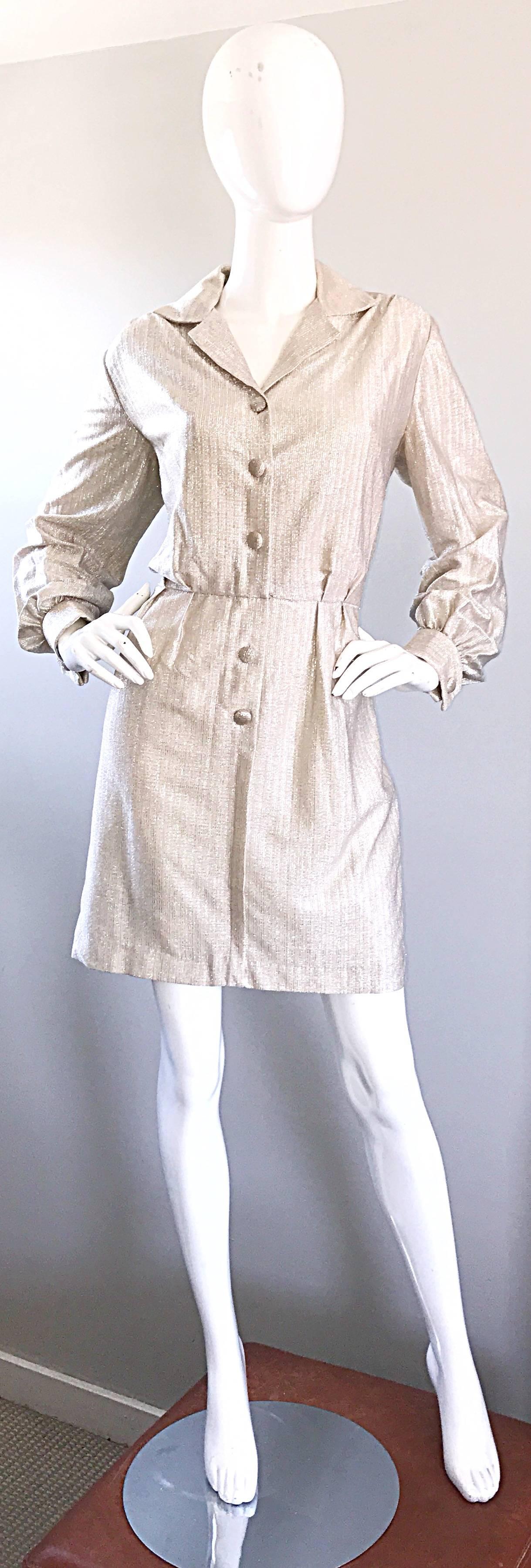 Chic 1970s white gold + silver metallic lurex long sleeve shirt dress! Features fabric covered buttons up the bodice and at each sleeve cuff. Hidden        hook-and-eye closure at front waist. Flattering pleating detail on the waist. Fully lined.
