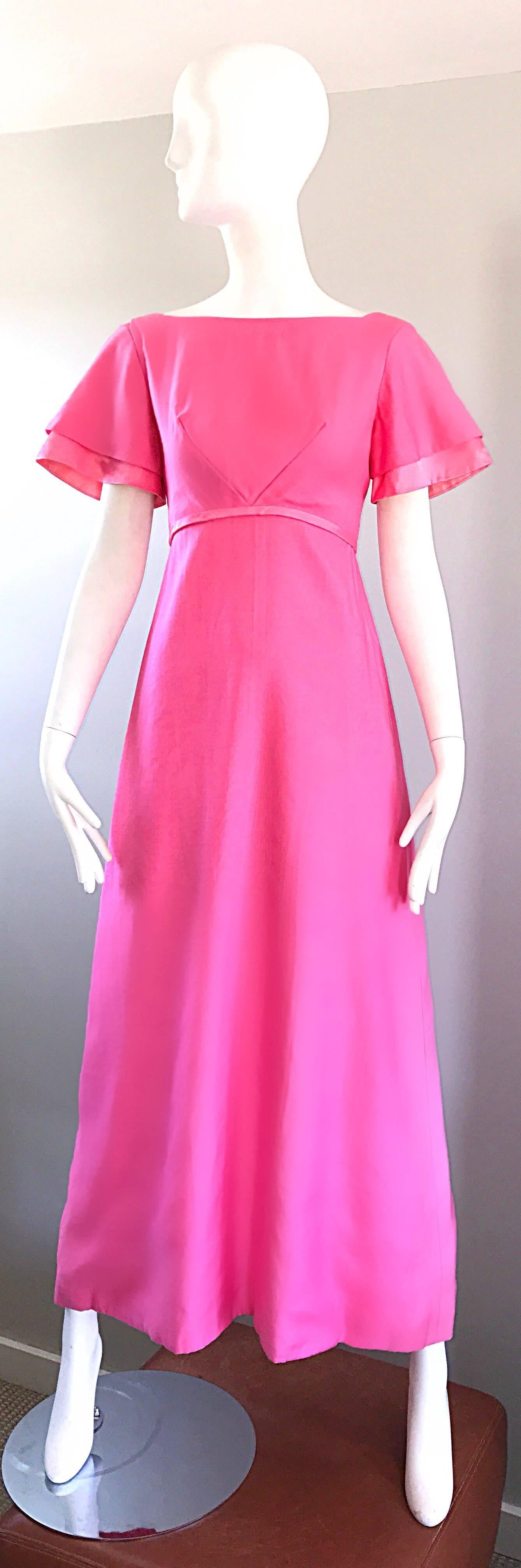 Amazing 1970s EMMBA DOMB bubblegum pink short sleeve cotton empire waist maxi dress! Vibrant pink color looks great on any skin tone. Fitted bodice with a full skirt. Chic bell sleeves, and an attached bow at center back. Full metal zipper up the