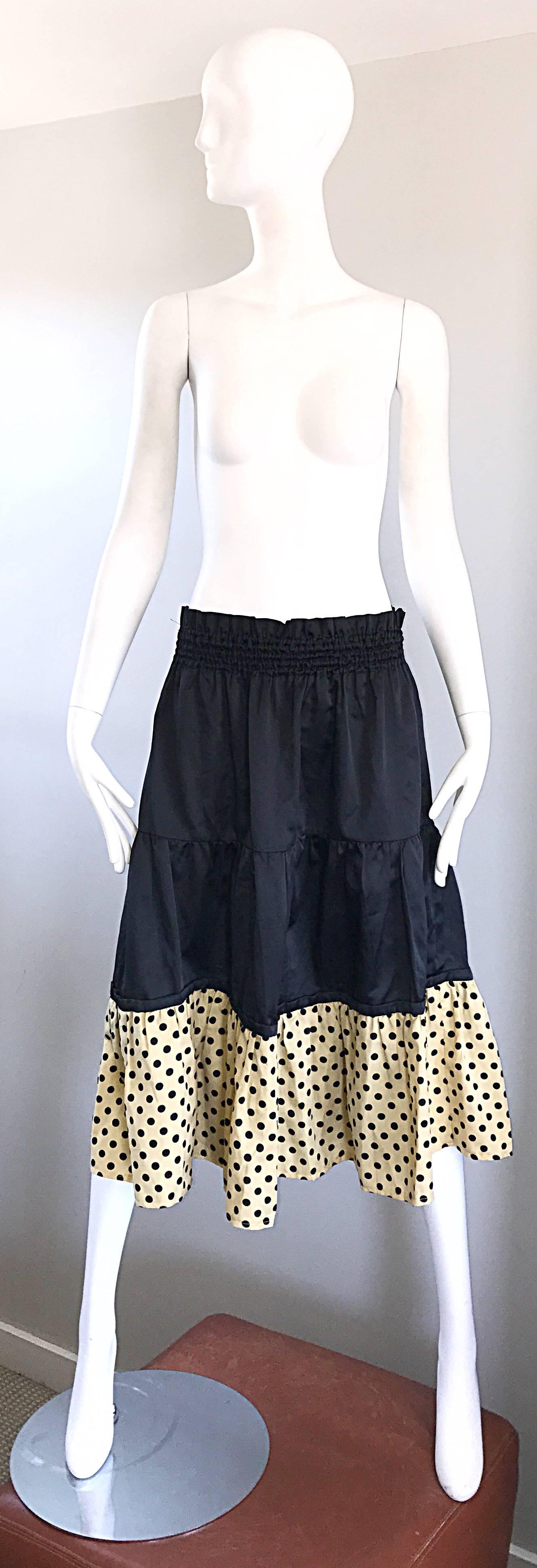 Chic 1970s PIERRE CARDIN black and ivory tiered ruffle polka dot midi skirt! Elastic waistband can accomodate an array of sizes. Simply slips over the head. Black tiers with and ivory and black polka dot hem. Can easily be dressed up or down. Great