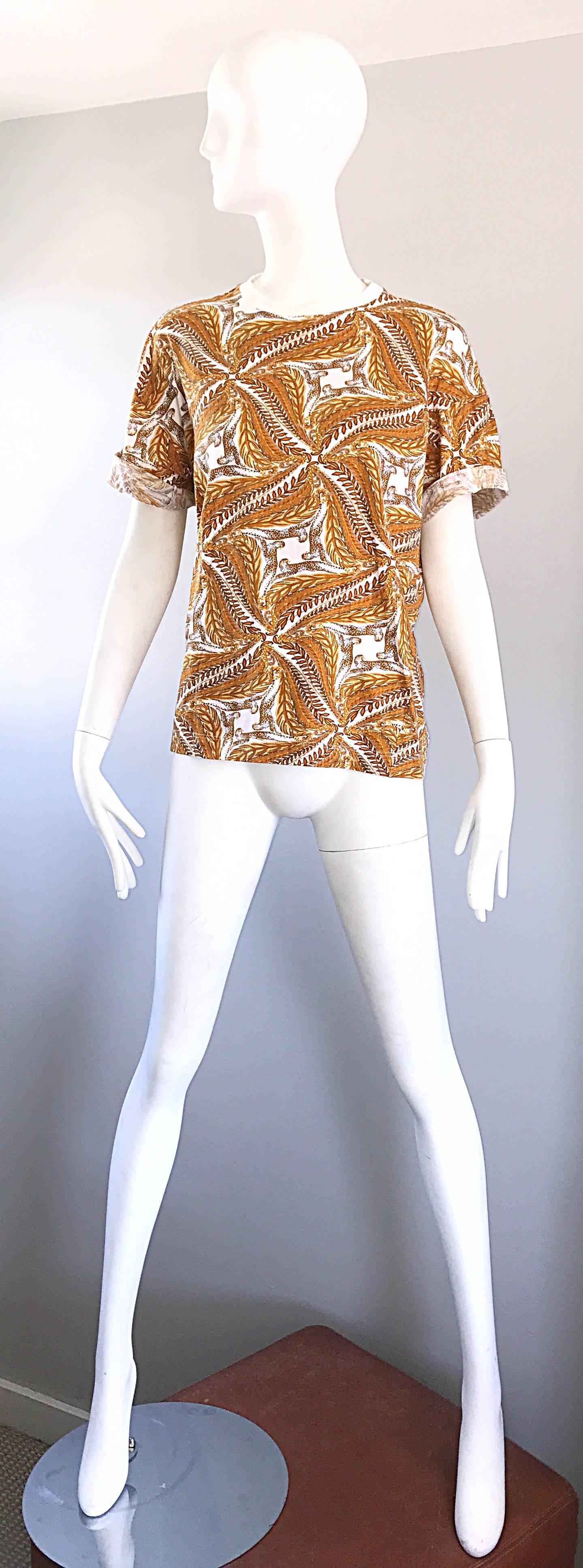 Chic t-shirt vintage SALVATORE FERRAGOMO en coton imprimé guépard/léopard et blé à manches courtes ! Comprend des imprimés symétriques en or, jaune, marigold et blanc. Les manches peuvent être portées retroussées pour un look plus tendance. Idéal