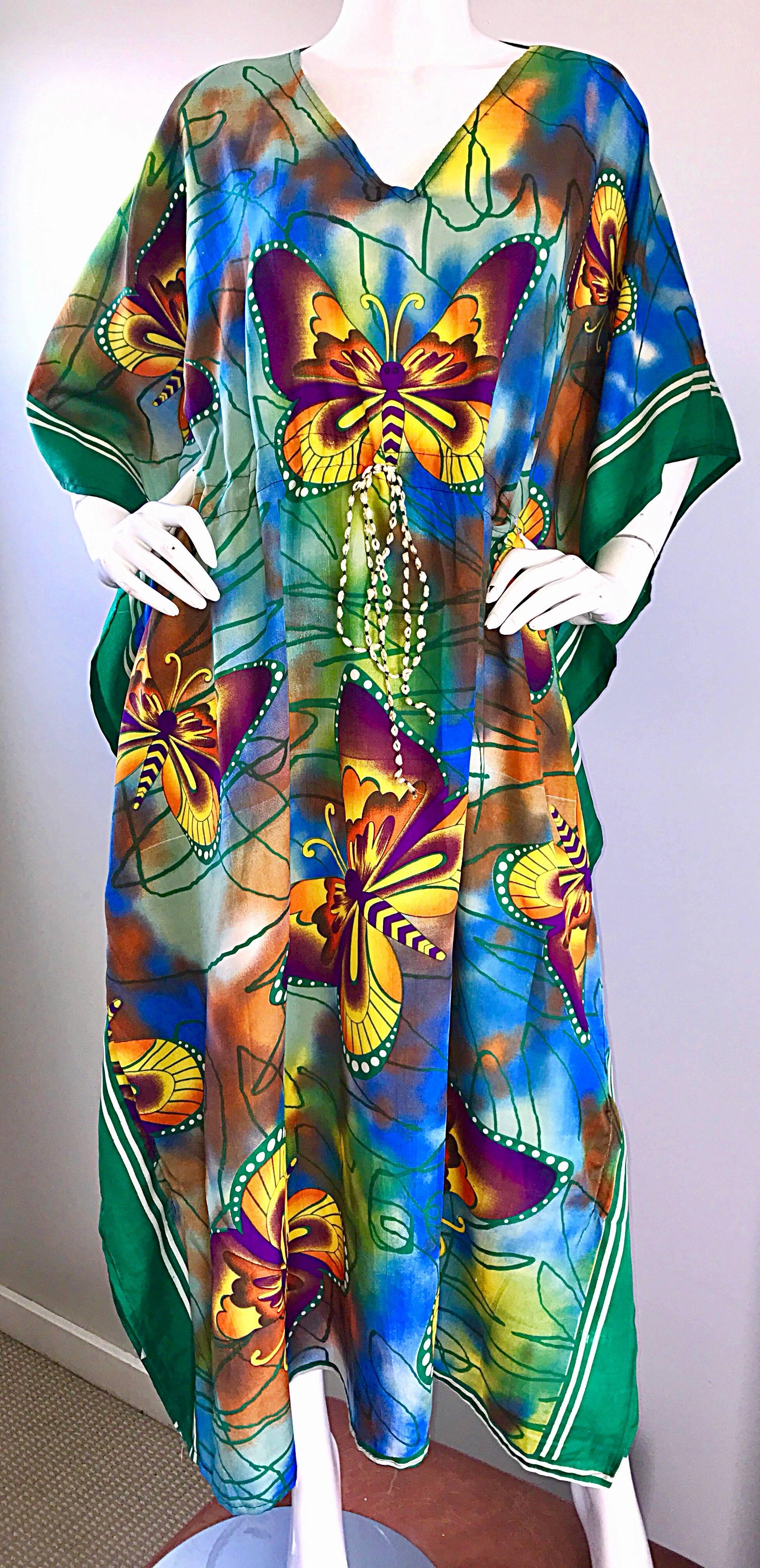 Amazing 1970s colorful butterfly kaftan! Features brightly colored butterflies in orange, yellow, purple throughout. Tie Dye print in blue, orange and green. Interior rope belt at the waist can adjust to fit smaller or larger. Impeccable