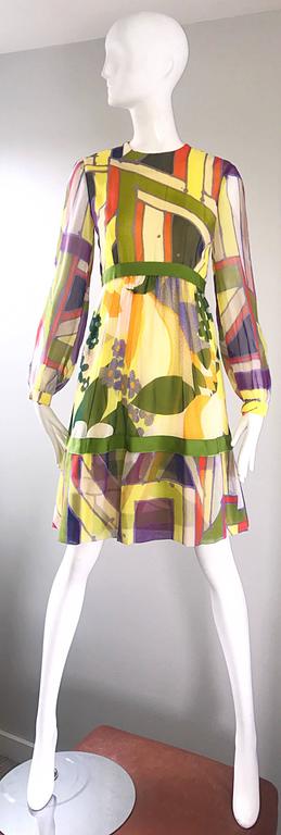 Exceptional 1960s RODRIGUES for NEIMAN MARCUS silk chiffon A-line babydoll dress! Features vibrant colors of yellow, chartreuse green, purple, and orange. Flower prints mixed with geometric shapes throughout. Semi sheer chiffon bishop sleeves with a