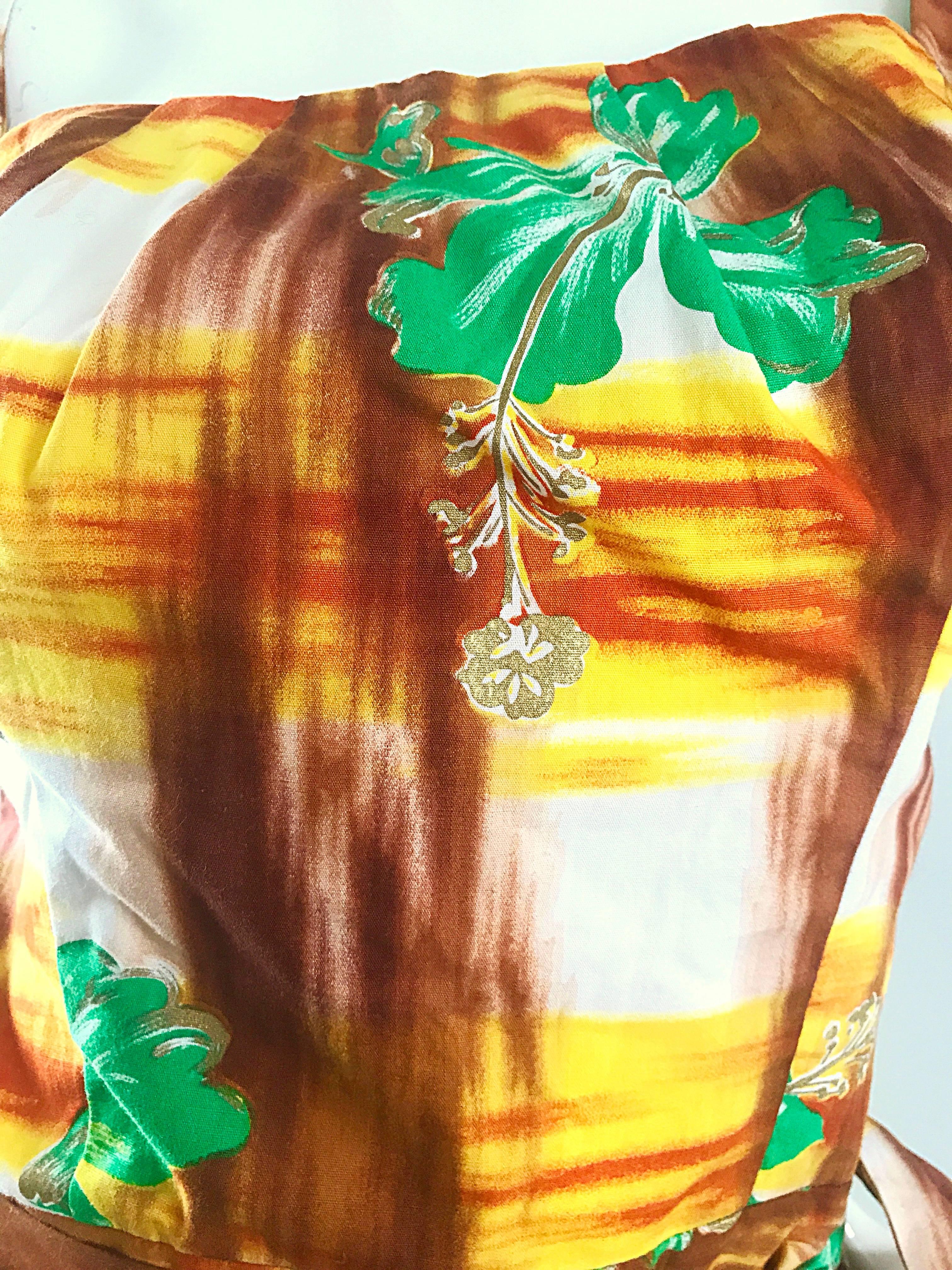 Beautiful 1950s KAMEHAMEHA hand painted vintage cotton wrap dress! Features vibrant handpainted prints in yellow, green, orange, gold, brown and white. Sarong style wrap ties shut at the left waist. Full metal zipper up the side with hook-and-eye