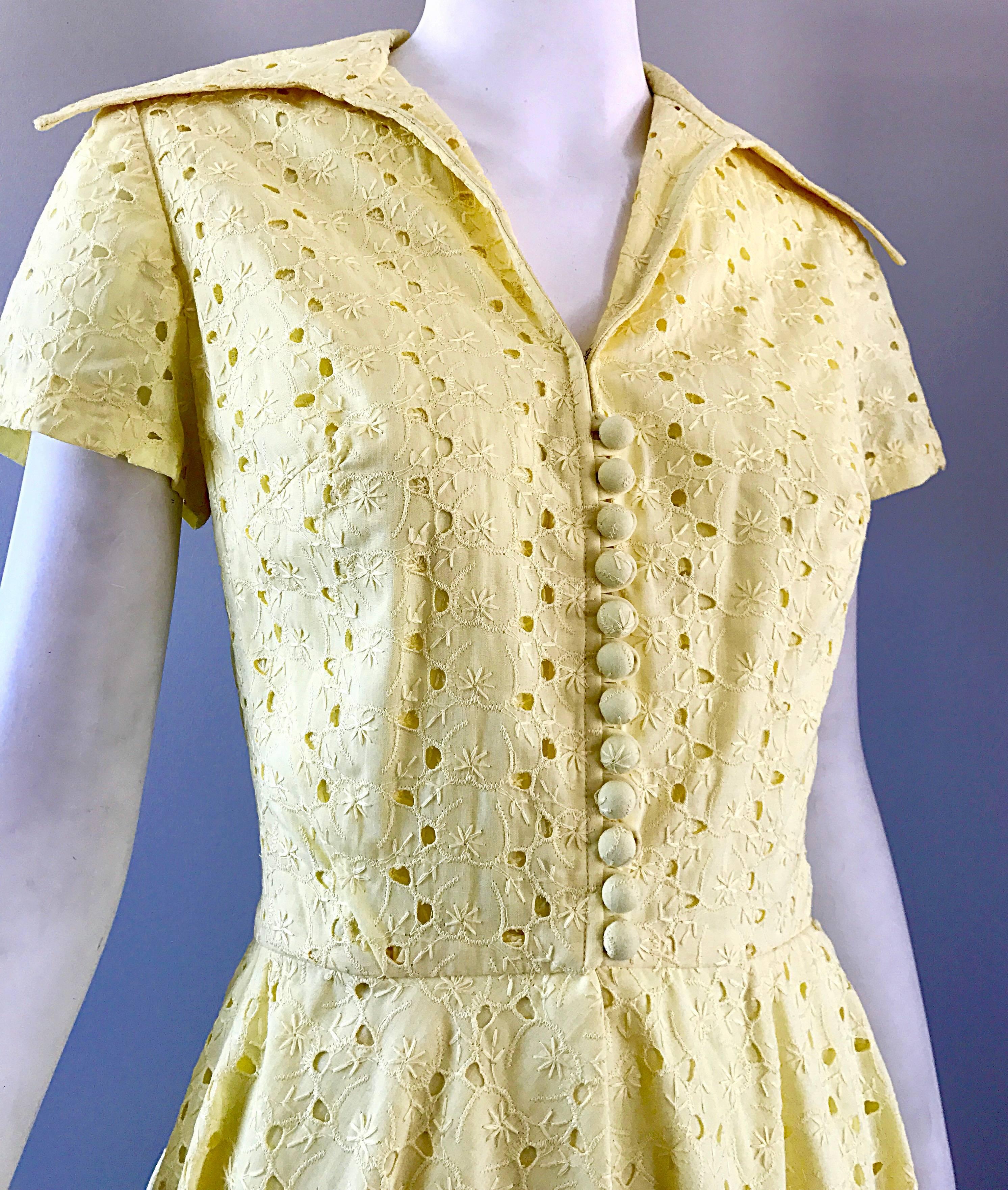 Gorgeous vintage 1950s pale yellow demi couture eyelet dress! Features embroidered eyelets throughout the entire dress. The entire dress is lined, with the exception of the back bodice. Chic embroidered buttons up the bodice, which is fitted, and